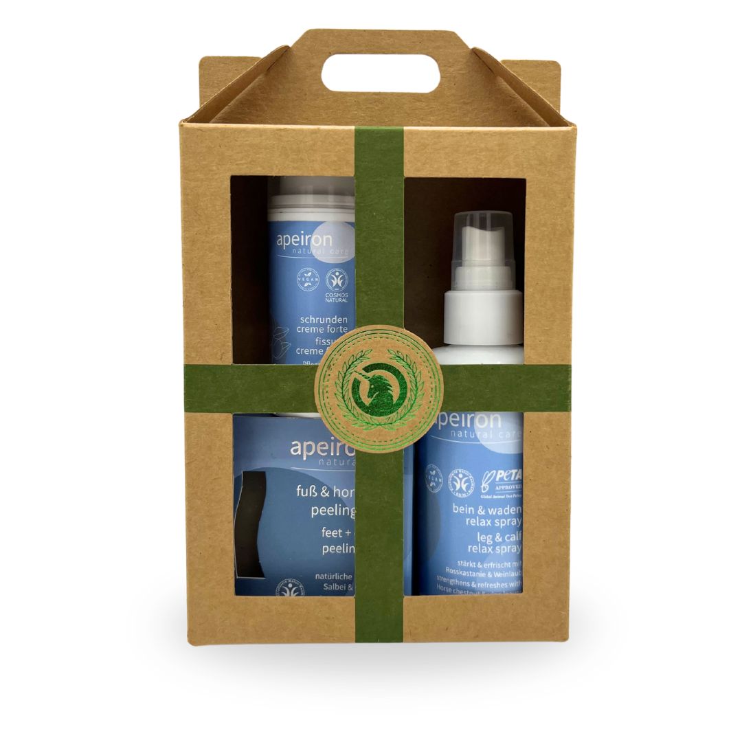 Geschenkbox mit Fußpflegeset. Enthält Creme, Spray und Seife. Braune Box mit grünem Band. "Apeiron" Logo.