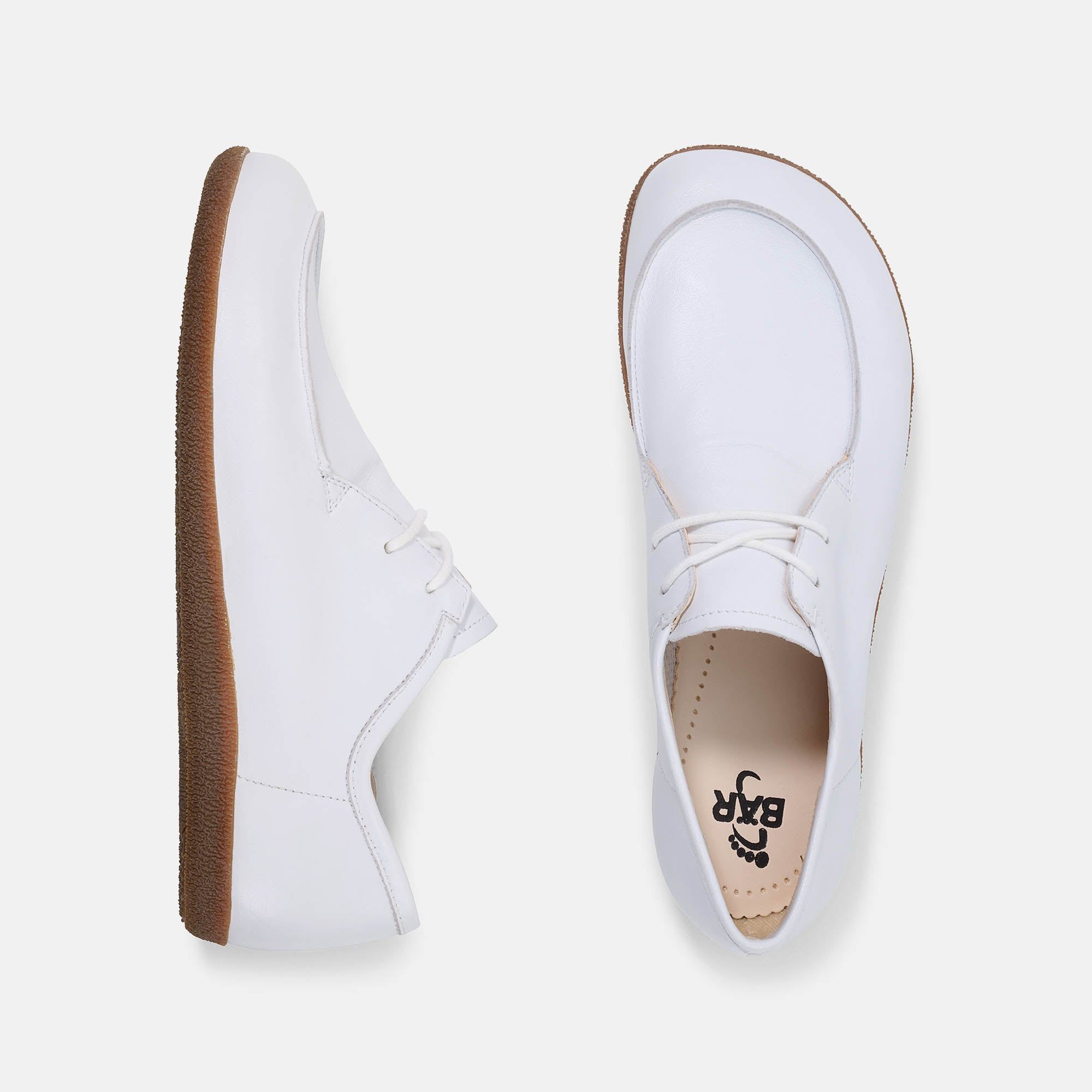 Zwei Schuhe, weiß, Schnürer, braune Sohle. Breiter Schnitt. BAR-Logo innen.