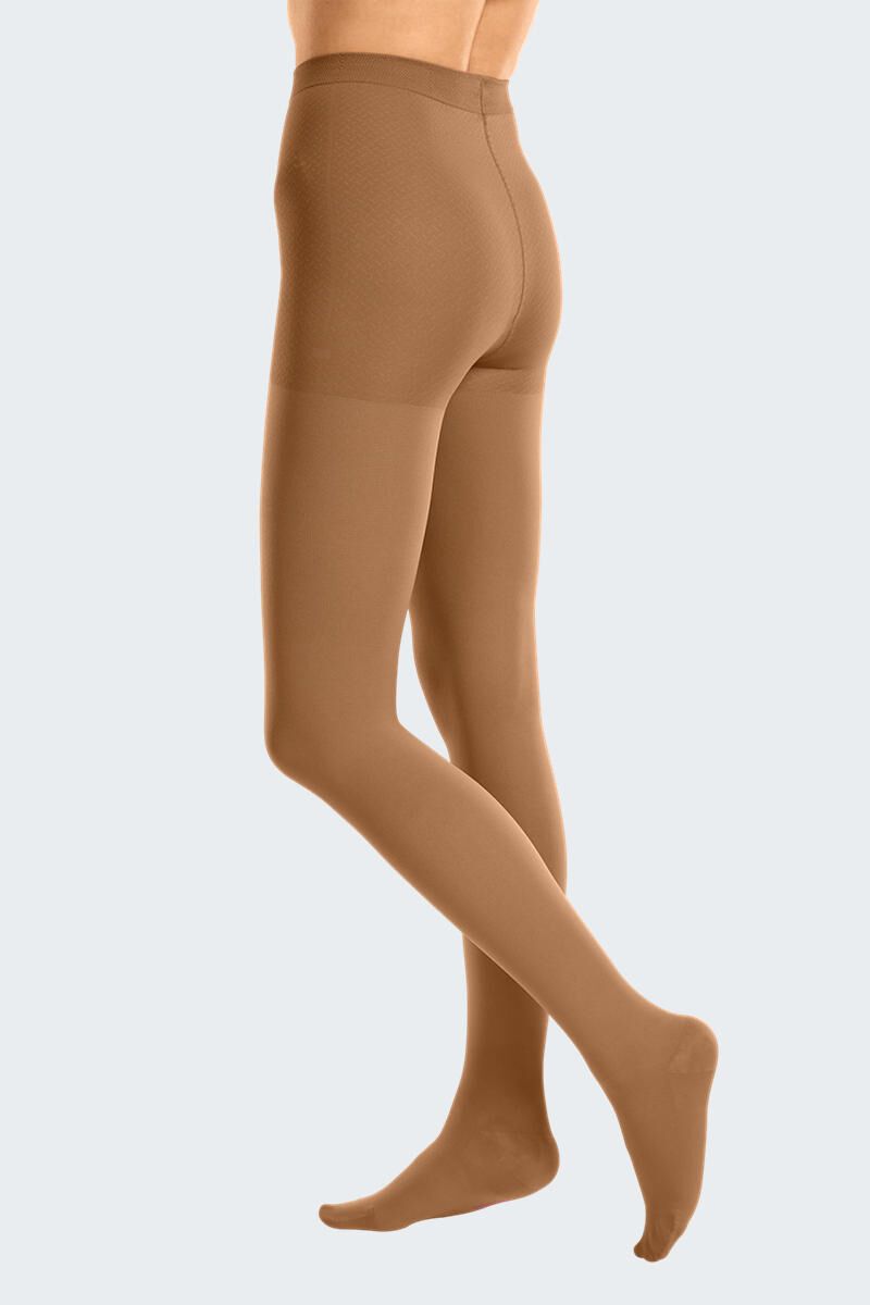 Hautfarbene Strumpfhose, seitliche Rückansicht. Beinbekleidung mit Fußteil, blickdicht. Angedeuteter Bund.