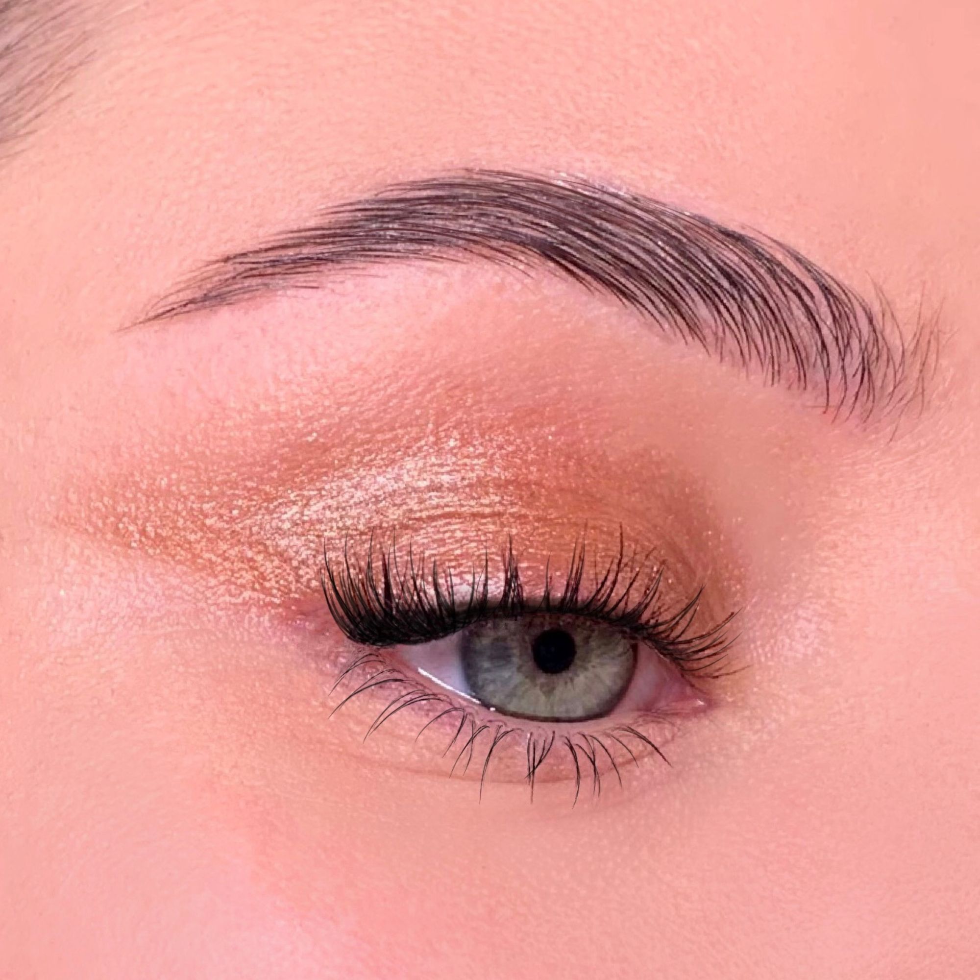 Nahaufnahme eines geschminkten Auges. Grüner Iris, Wimpern, Augenbraue. Lidschatten. Hautton.