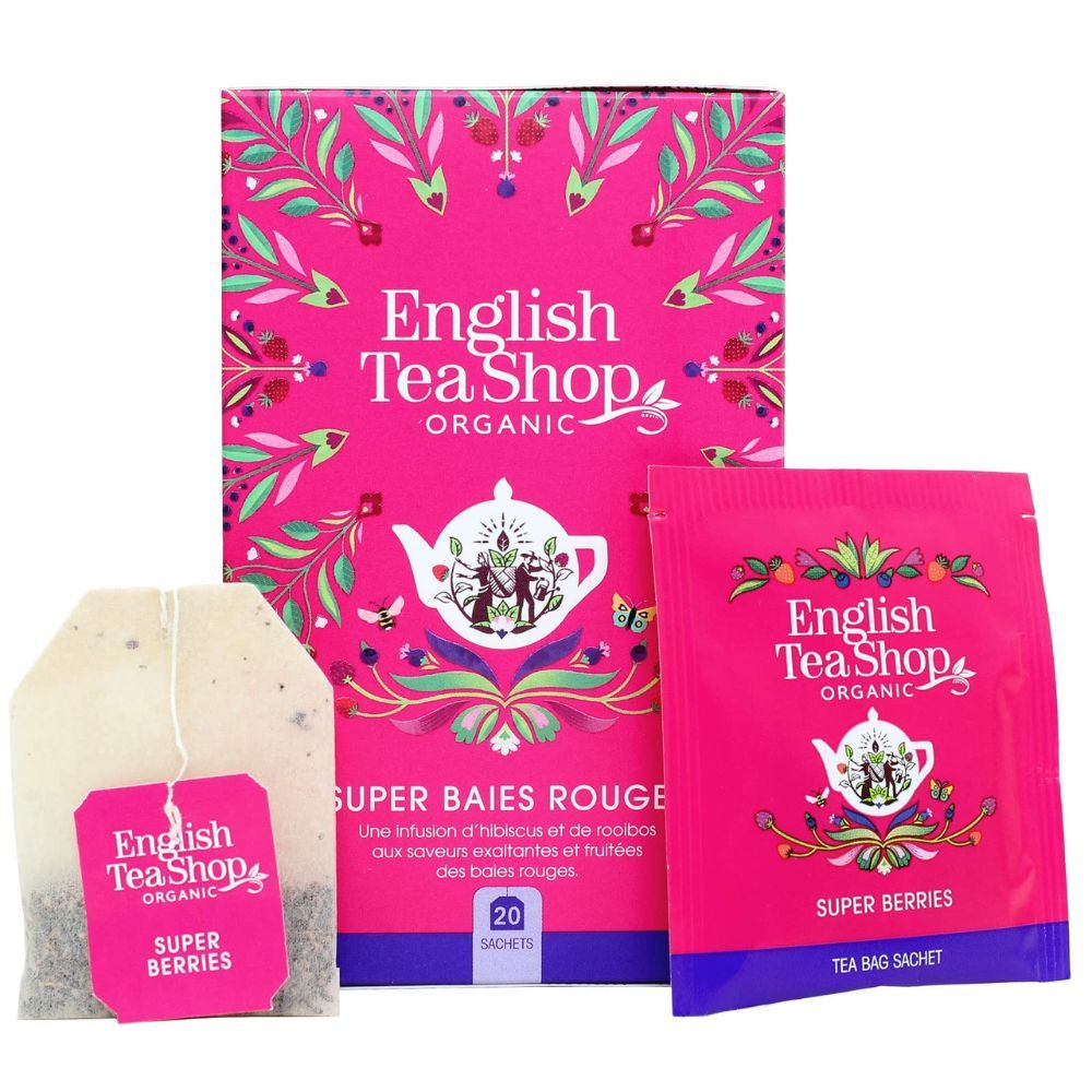 Rosa Schachtel mit Teebeuteln. Aufschrift: English Tea Shop Organic, Super Beeren. Einzelner Teebeutel und Beutel mit Aufschrift.