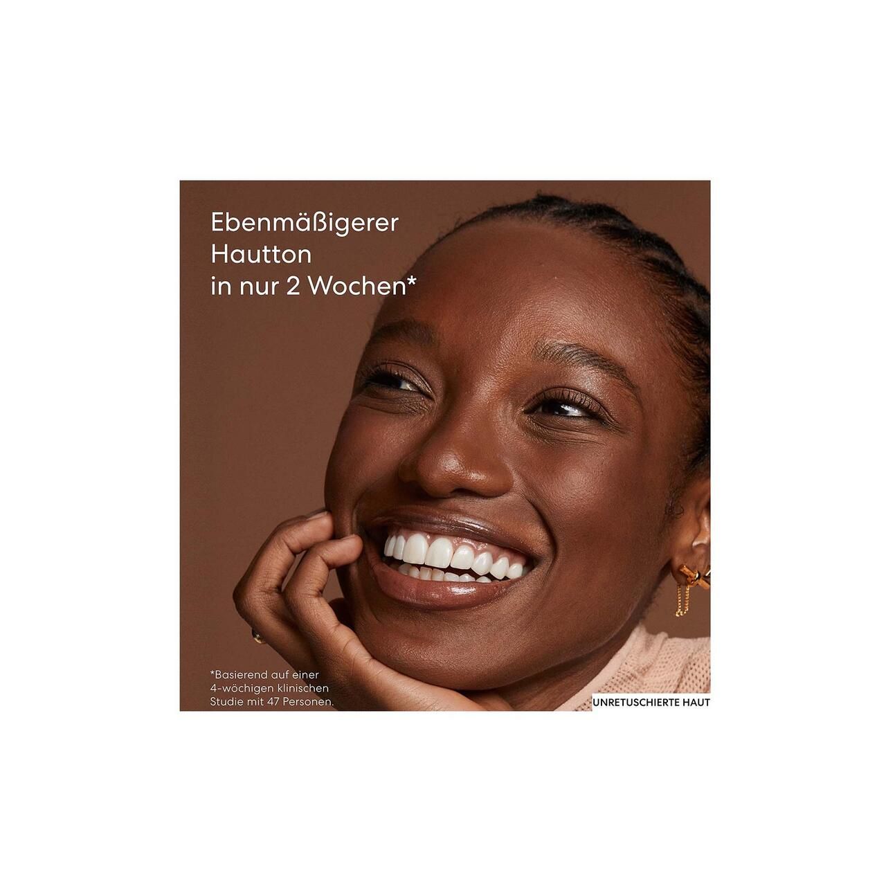 Nahaufnahme eines lächelnden Gesichts. Text über Hautton. Unretuschierte Haut. Produktanwendung.