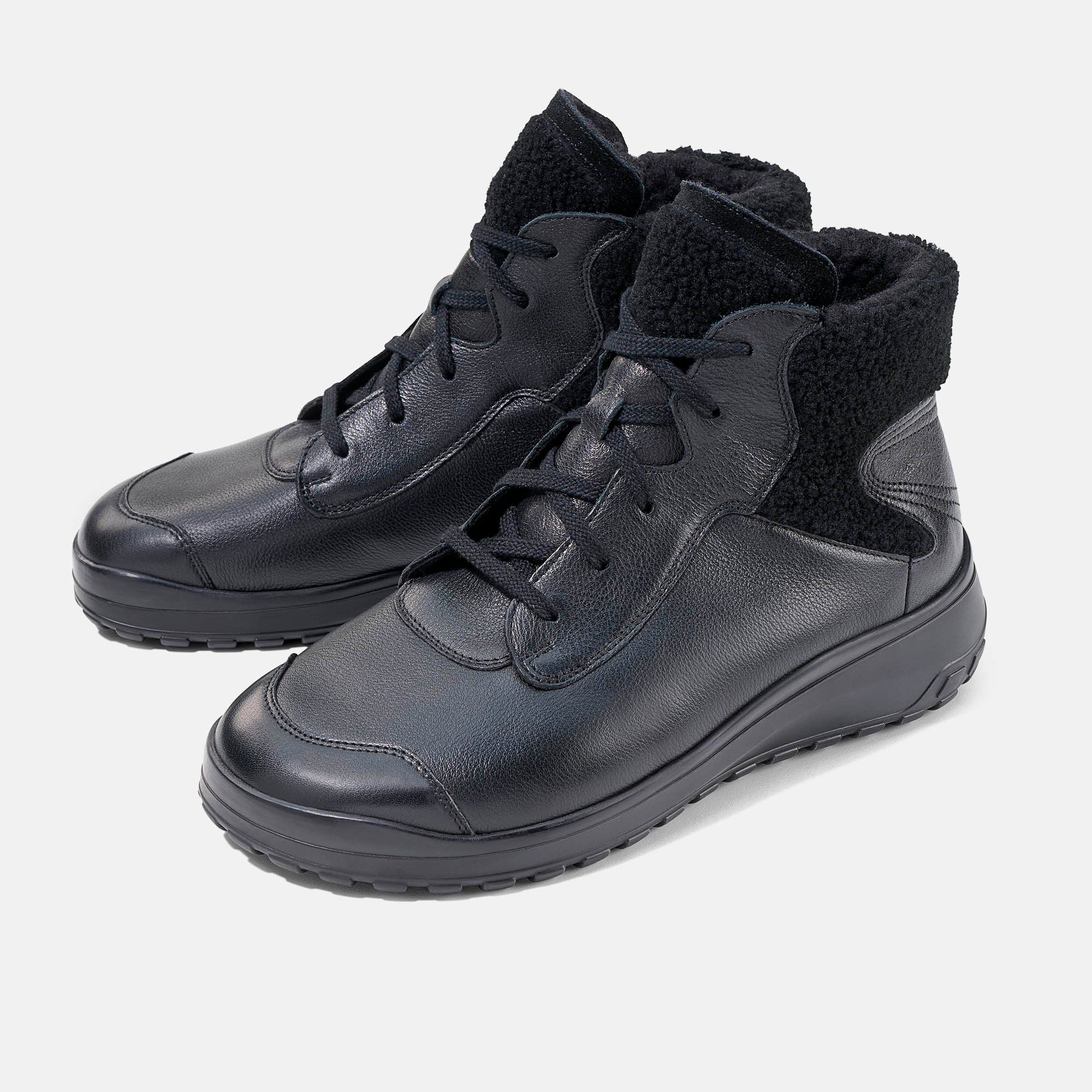 Schwarze Damen-Stiefeletten aus Leder, Seitenansicht mit Lammfellfutter.