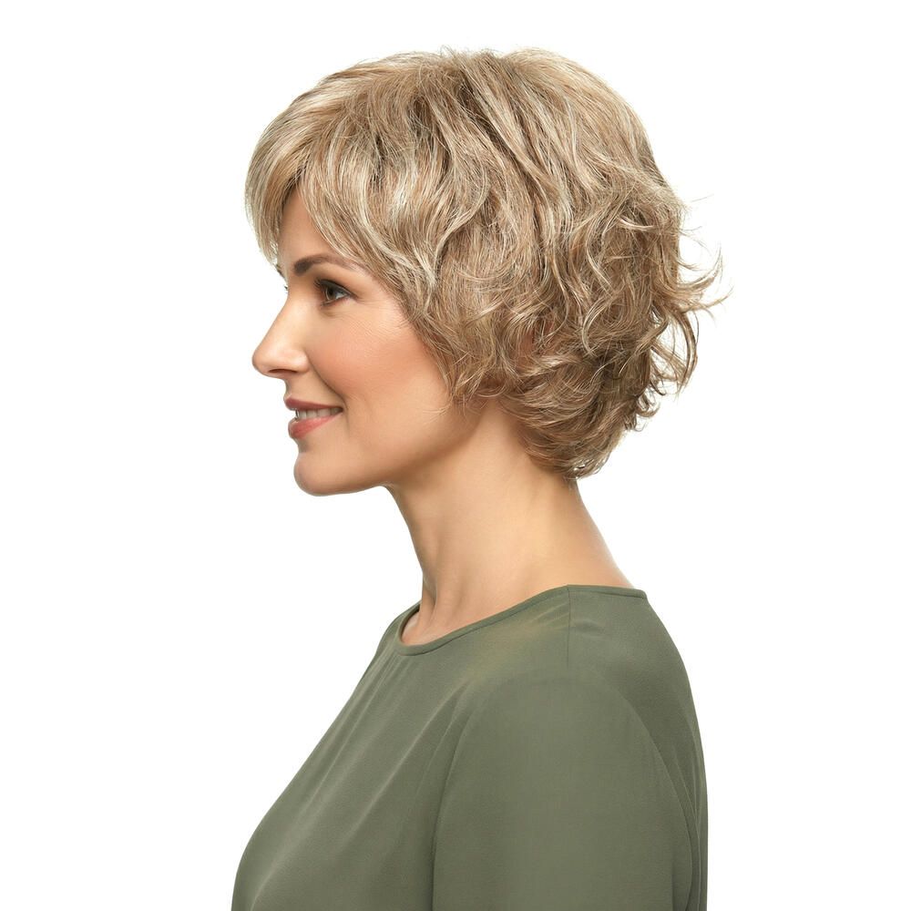 Kurzhaarperücke mit blonden Strähnen. Seitenansicht einer Frau mit Perücke und grünem Oberteil. Profilansicht.
