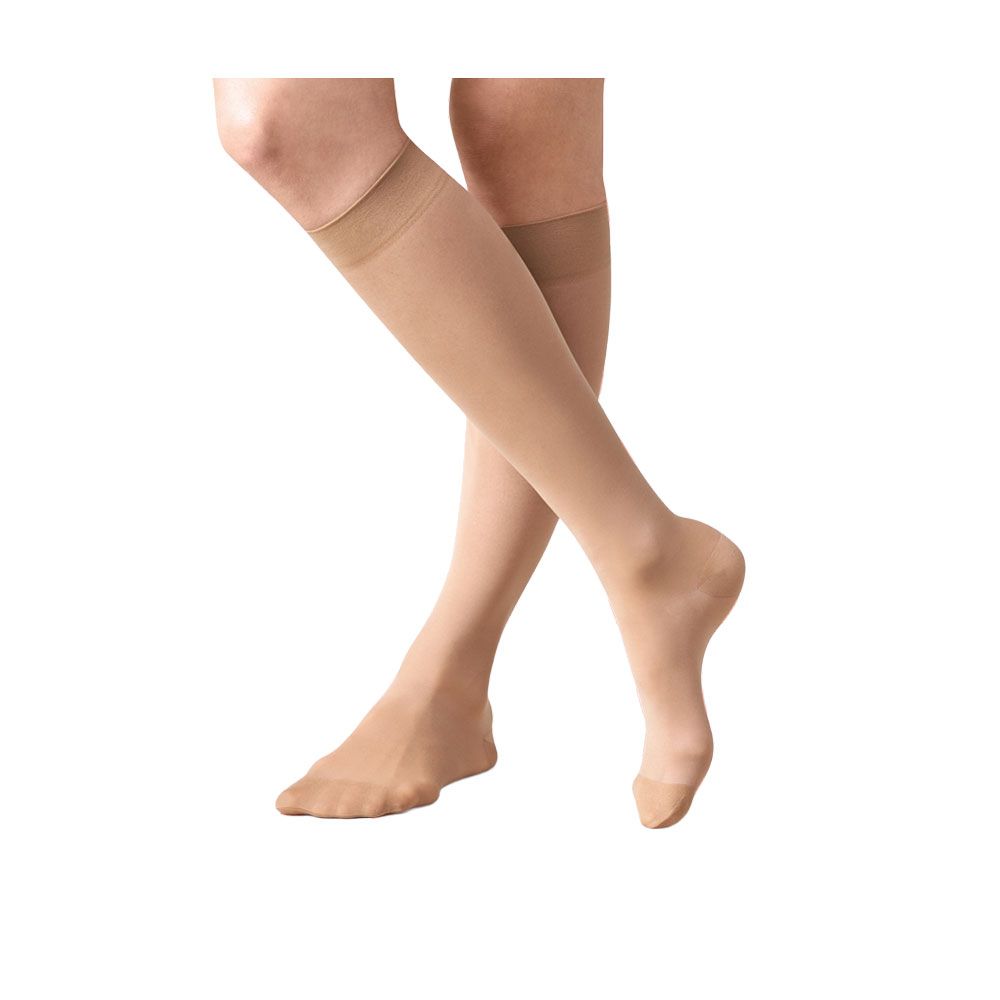 Hautfarbene Kniestrümpfe. Blick auf zwei Beine, die sich kreuzen. Feines Material, leicht transparent.