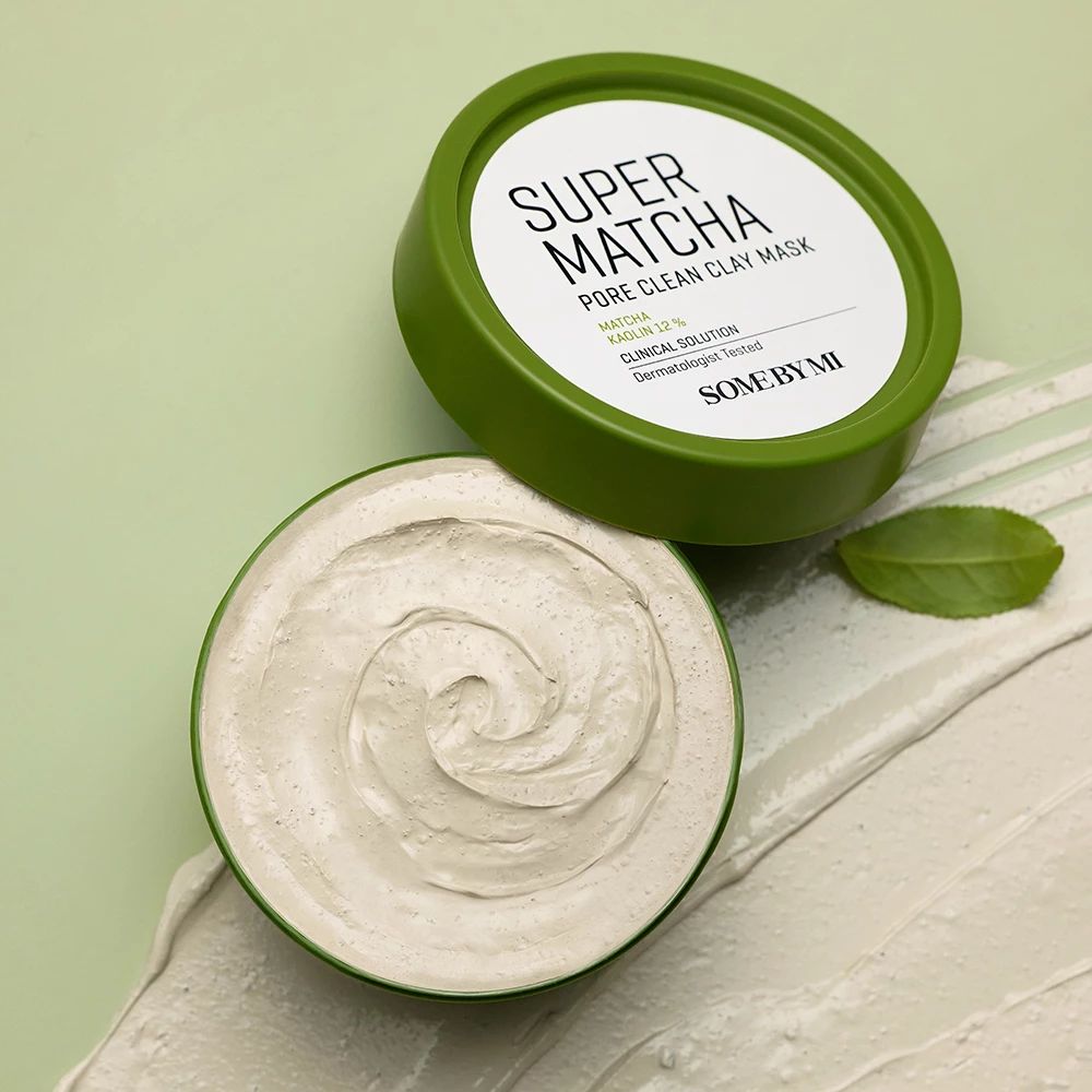 Grüner Behälter mit Deckel. Aufschrift: Super Matcha Pore Clean Clay Mask. Maske auf heller Oberfläche.