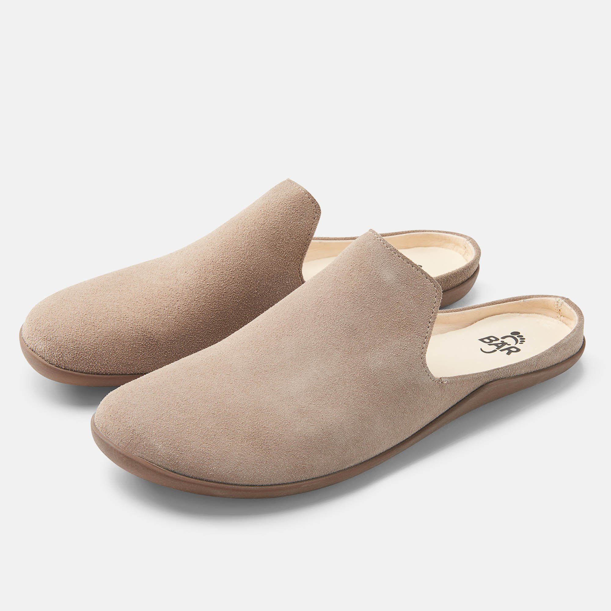 Zwei beigefarbene Pantoletten. Obermaterial aus Wildleder, braune Sohle. Innensohle mit Logo.