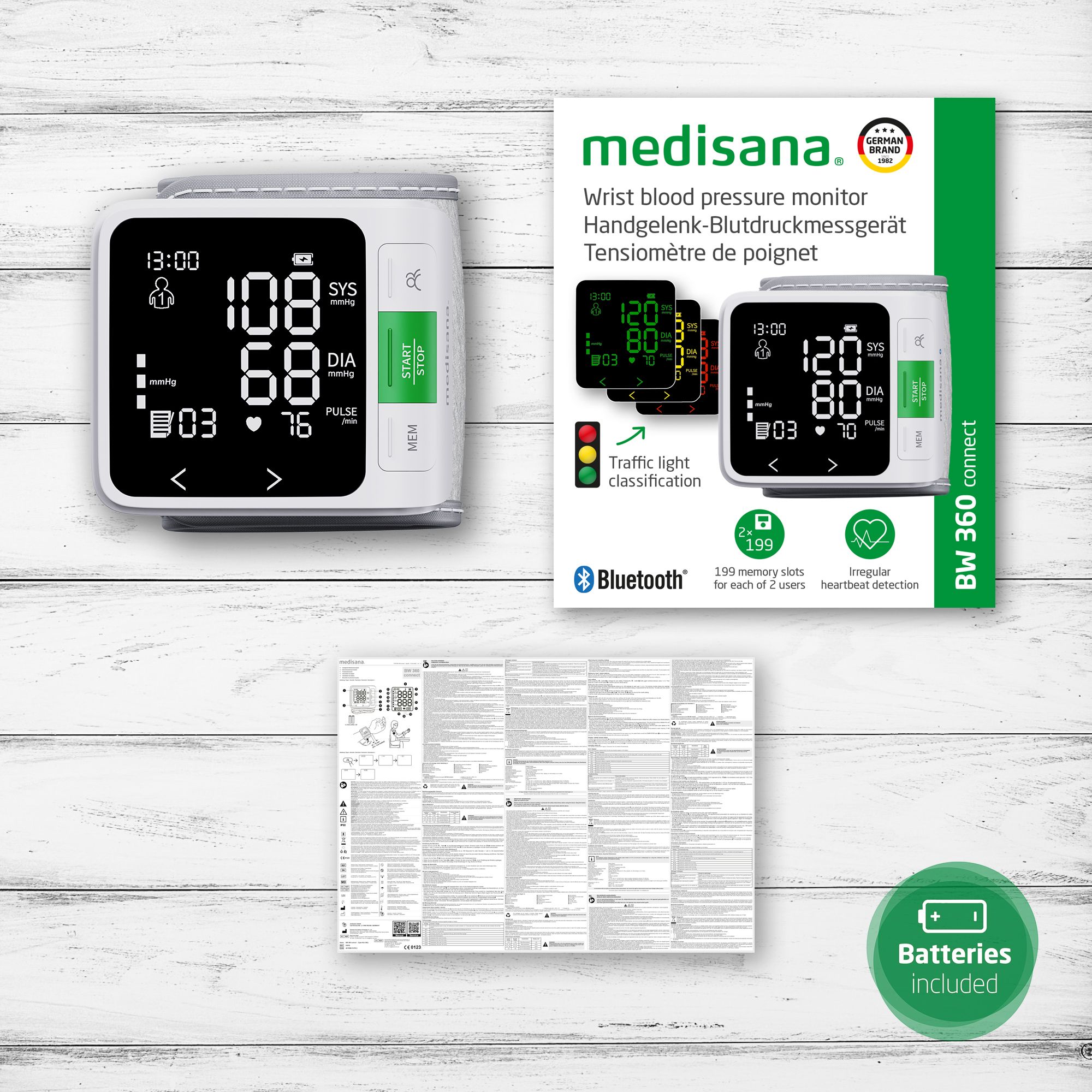 Handgelenk-Blutdruckmessgerät und Verpackung. Display zeigt Messwerte. Bedienungsanleitung und Batterien. Bluetooth.