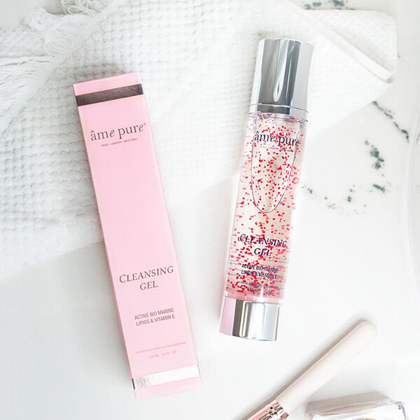 Fles en verpakking met "âme pure" en "Cleansing GEL" tekst. Rode deeltjes in het product. Op witte achtergrond.