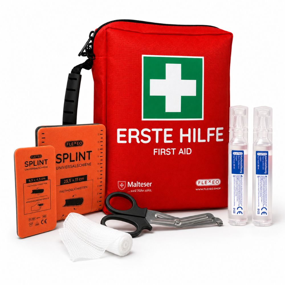 Rote Erste-Hilfe-Tasche mit Verbandsmaterial, Schere und Augenspülflaschen.