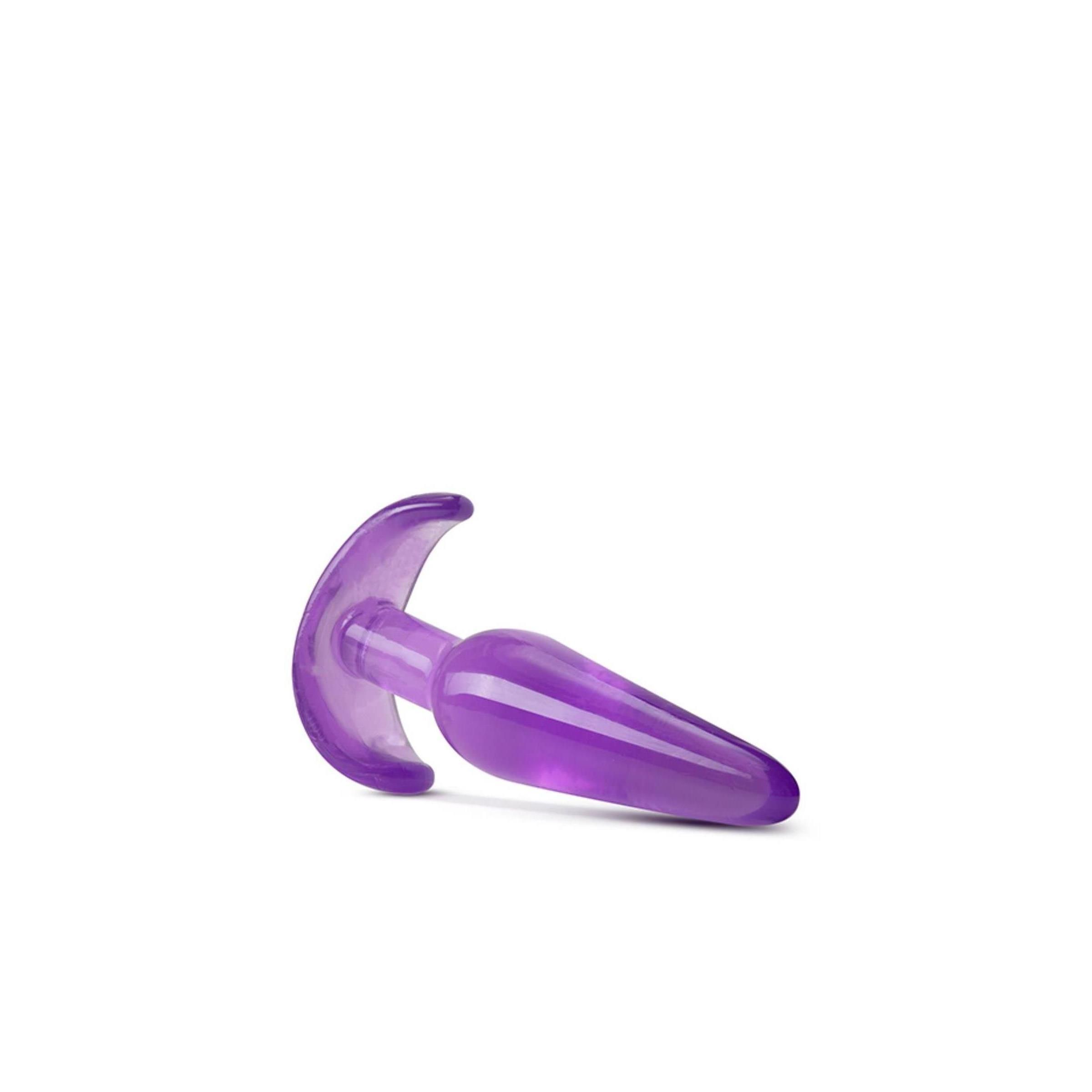 Lila Analplug. Konische Spitze, gebogene Basis. Liegend. Transparentes Material.