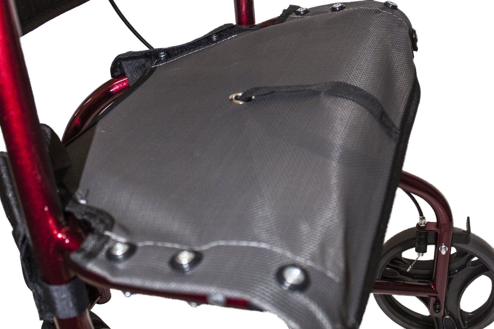 Nahaufnahme des schwarzen Sitzes eines Dreirad-Rollators. Schwarzes Netzmaterial, Metallnieten, Befestigung.