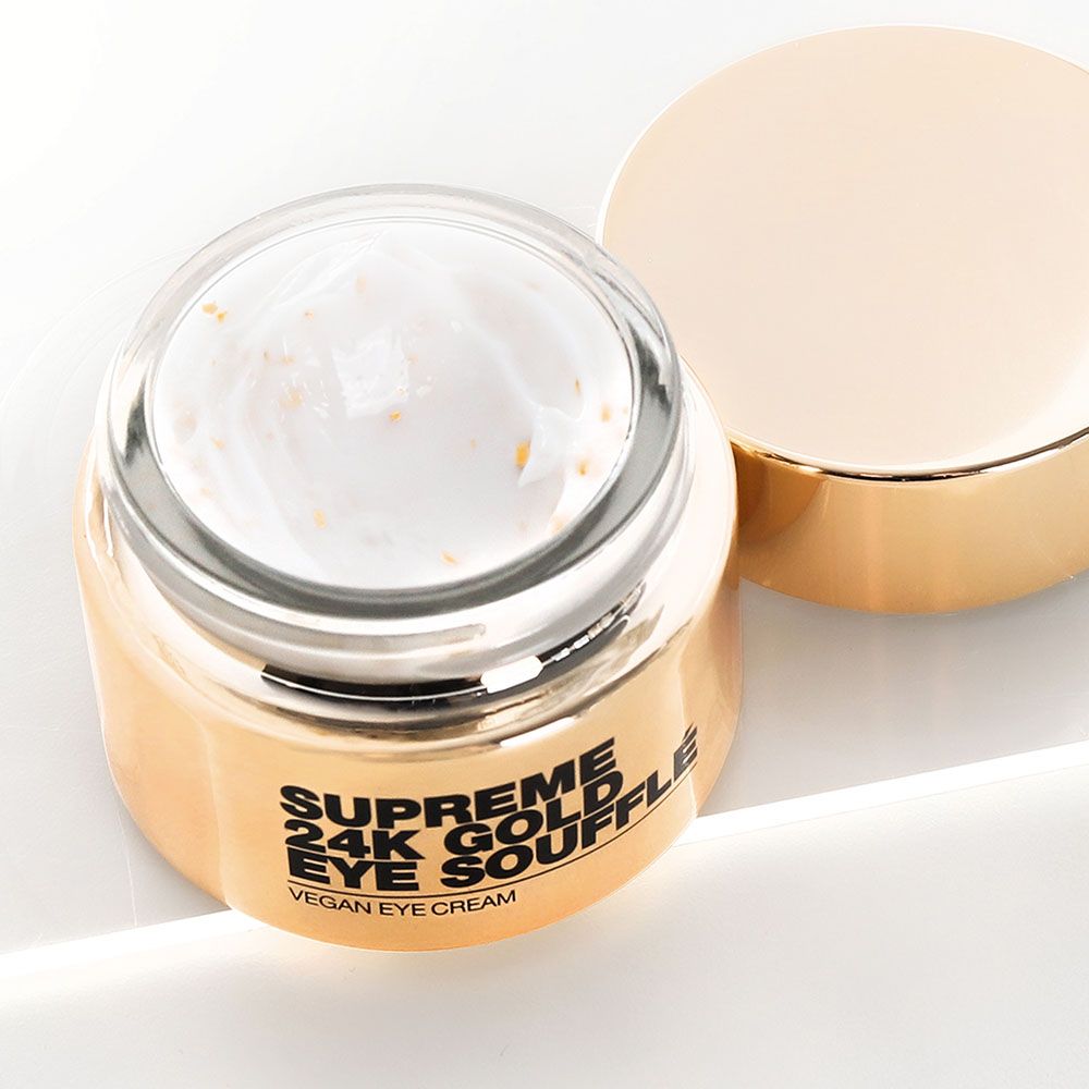 Geöffneter goldfarbener Tiegel. Innen Creme mit goldenen Partikeln. Aufschrift: Supreme 24K Gold Eye Soufflé, Vegan Eye Cream.