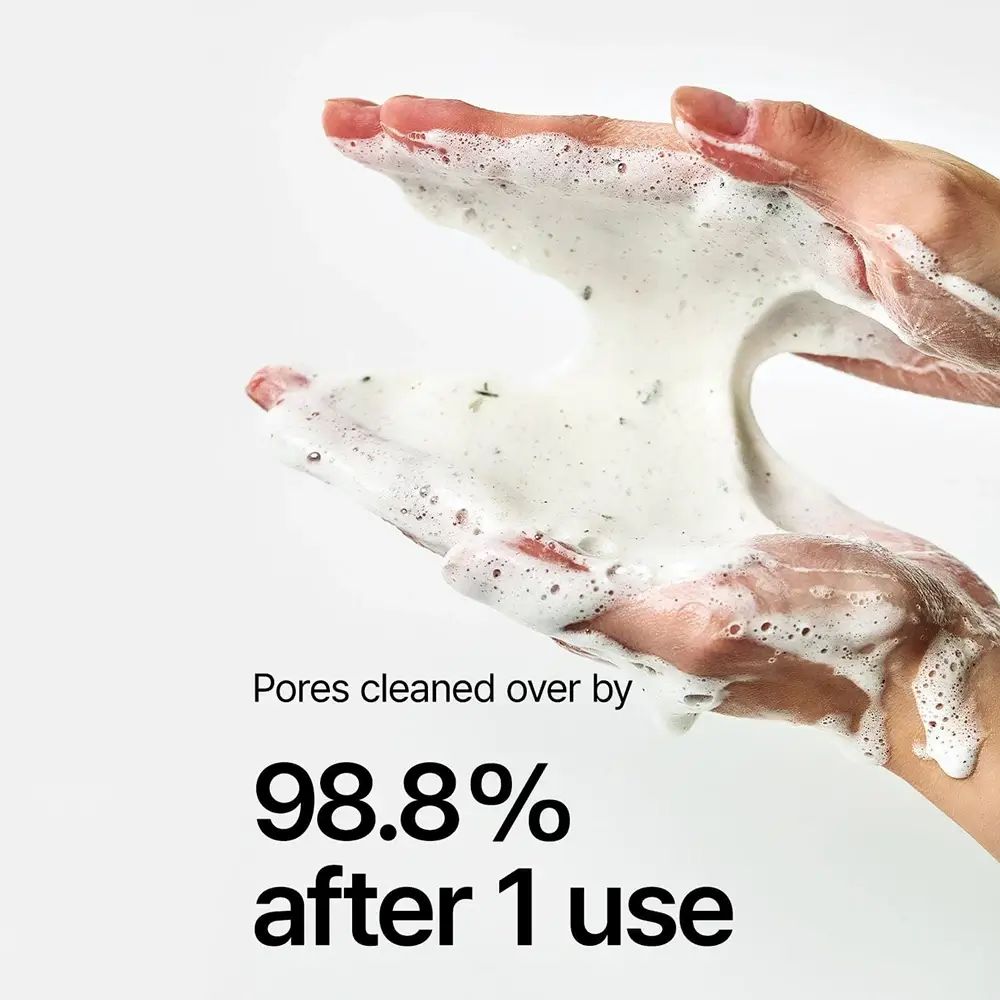 Hände mit Schaum. Text: Poren zu 98,8% nach 1 Anwendung gereinigt. Weißer Hintergrund. Keine Produktbezeichnung sichtbar.