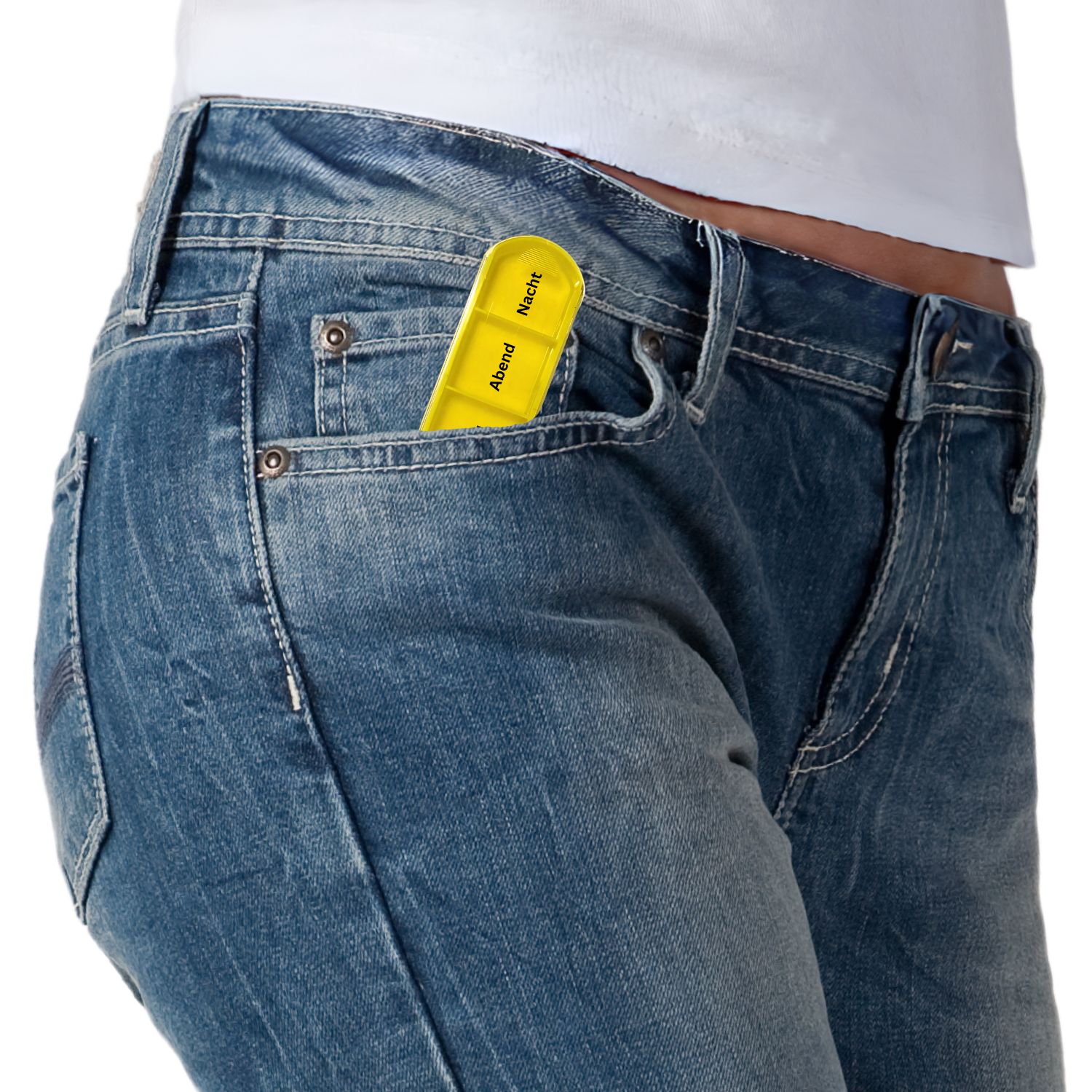 Gelbes Tablettenfach in einer Jeans-Hosentasche. Beschriftung mit Abend und Nacht.