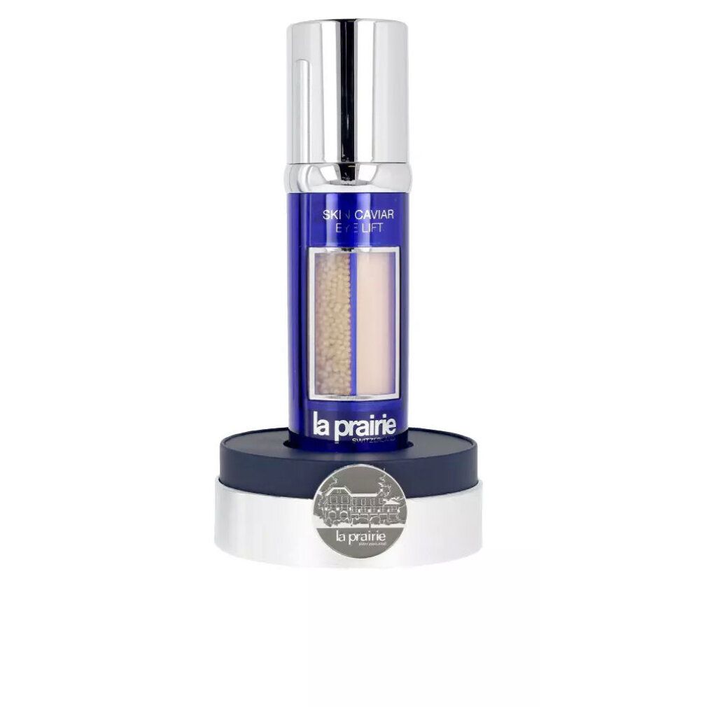 Flakon mit blauem Etikett, Produktbezeichnung und sichtbaren Kügelchen. Flakon steht auf einem Sockel. Marke La Prairie.