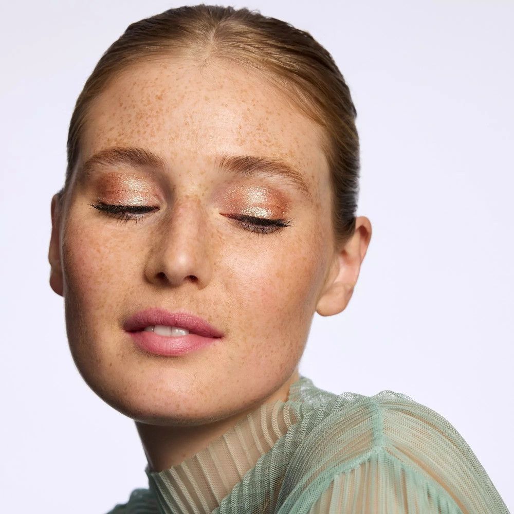 Porträt einer Frau mit geschlossenen Augen und aufgetragenem Lidschatten.