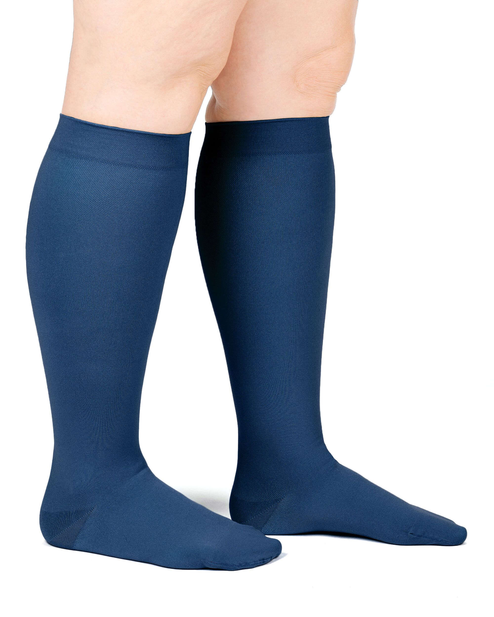 Person trägt dunkelblaue Kompressionsstrümpfe. Beide Beine sind sichtbar. Produkt ist am Bein getragen.