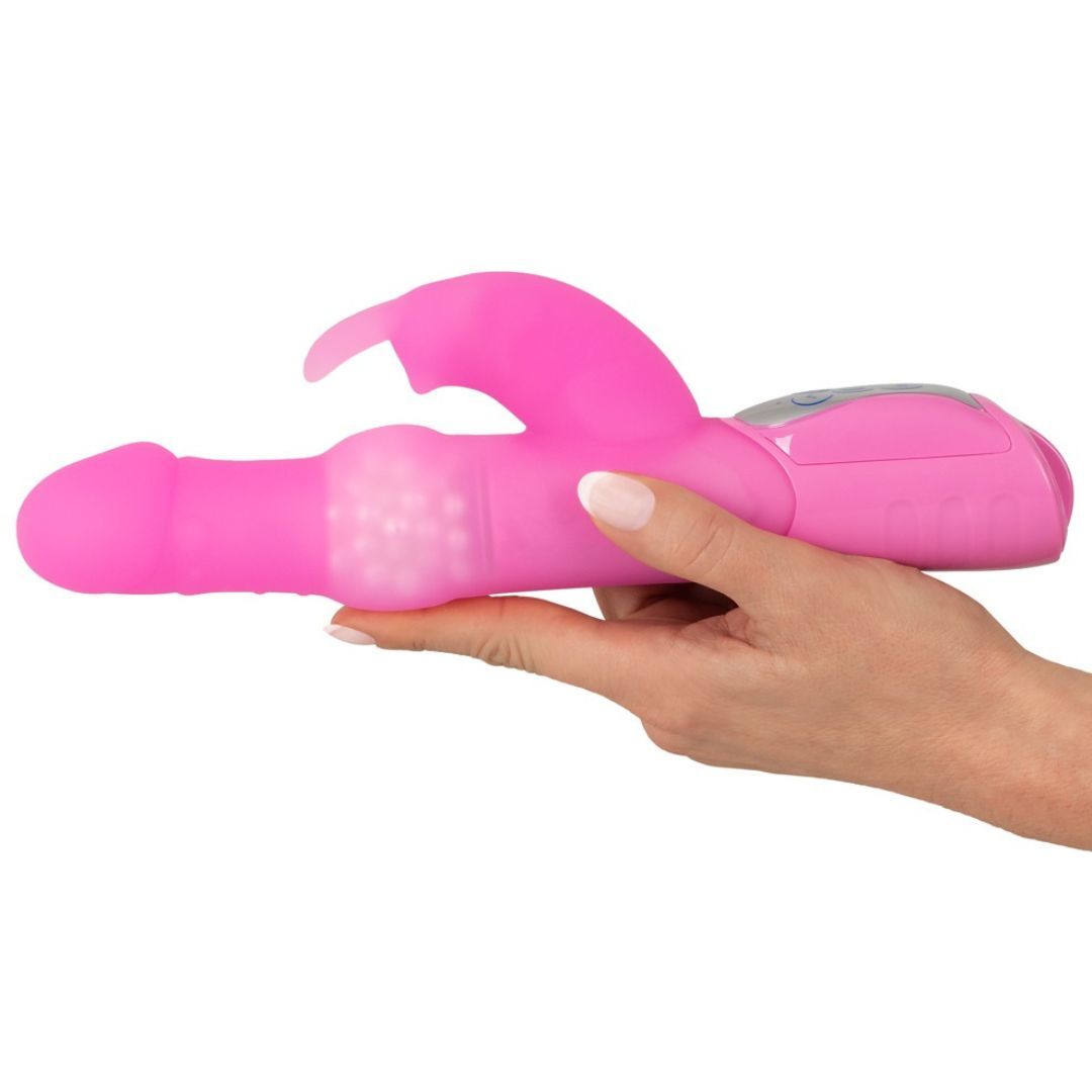 Rosa Vibrator, gehalten von einer Hand. Mit Kaninchenohren-Design und strukturiertem Mittelteil.