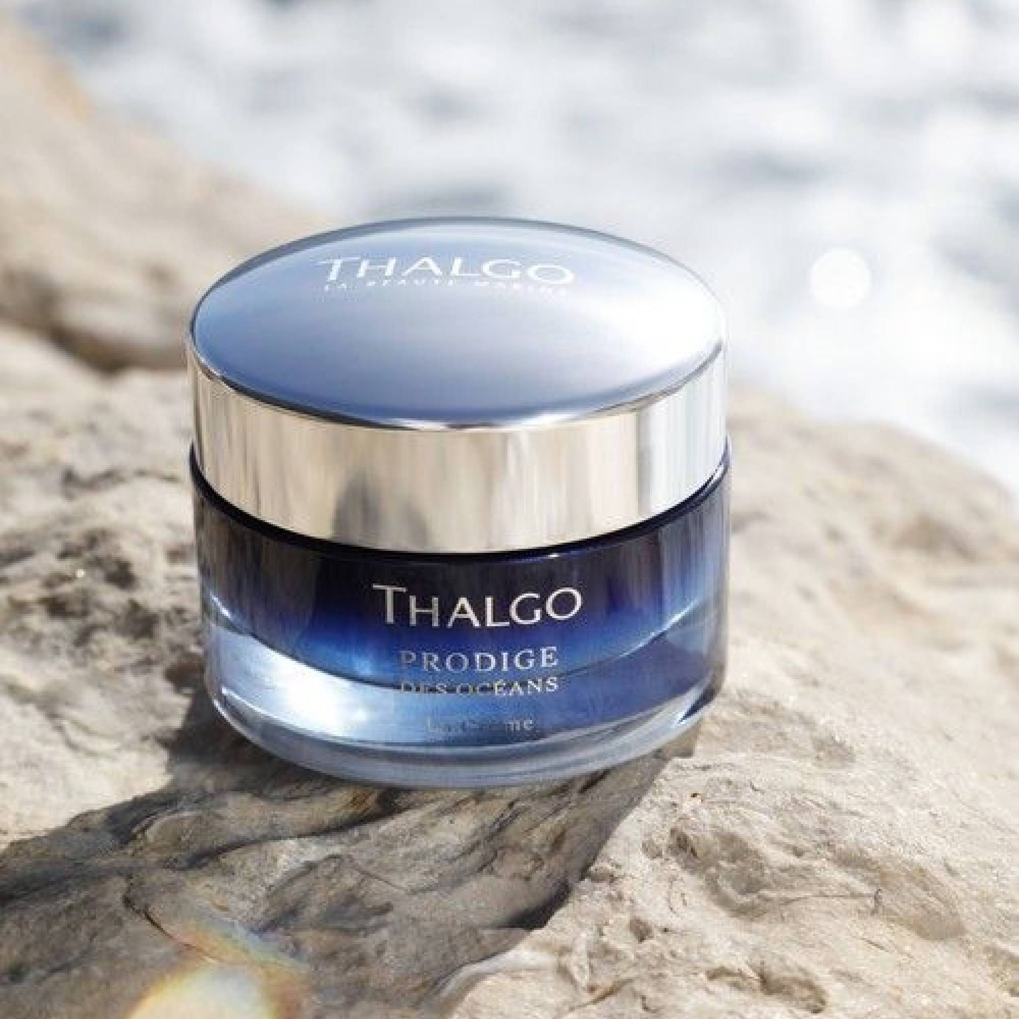Creme-Tiegel auf Stein. Silberner Deckel. Schriftzug: THALGO, PRODIGE DES OCEANS, La Crème.