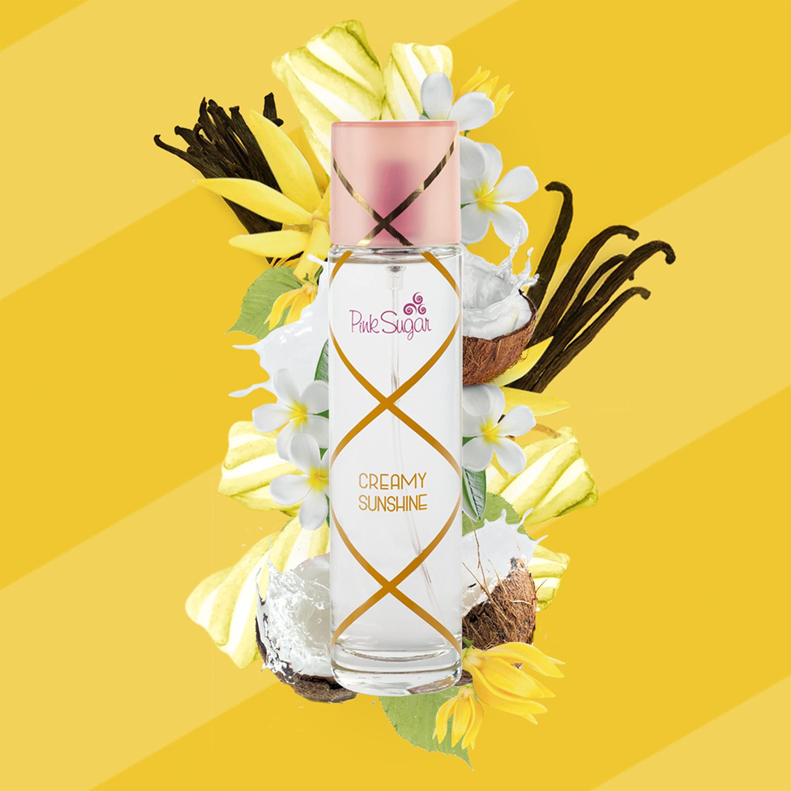 Parfümflasche mit rosa Deckel, umgeben von Blumen und Früchten. Aufschrift: Pink Sugar Creamy Sunshine.