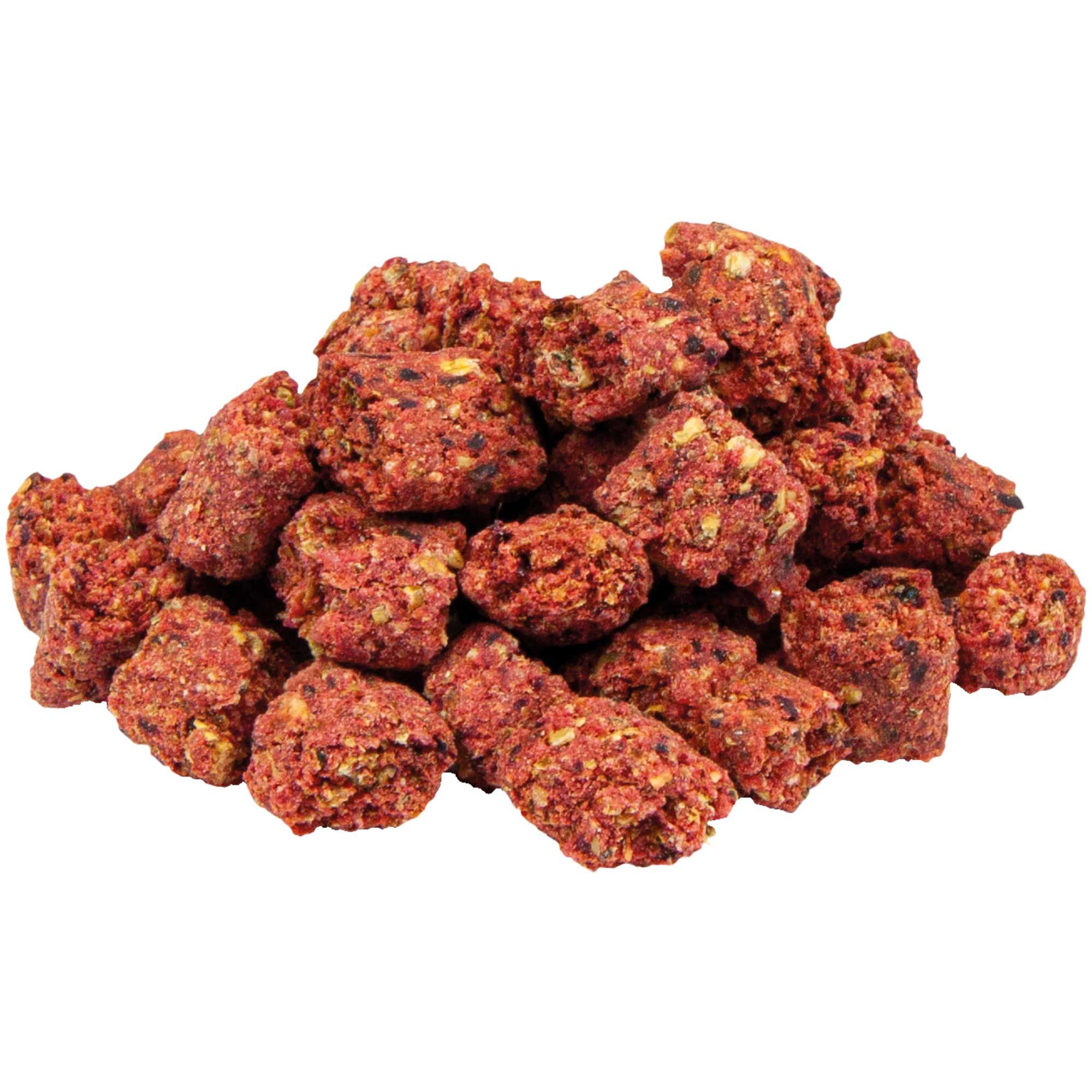Haufen von roten, unregelmäßig geformten Hundesnacks. Die Snacks weisen eine körnige Textur auf.