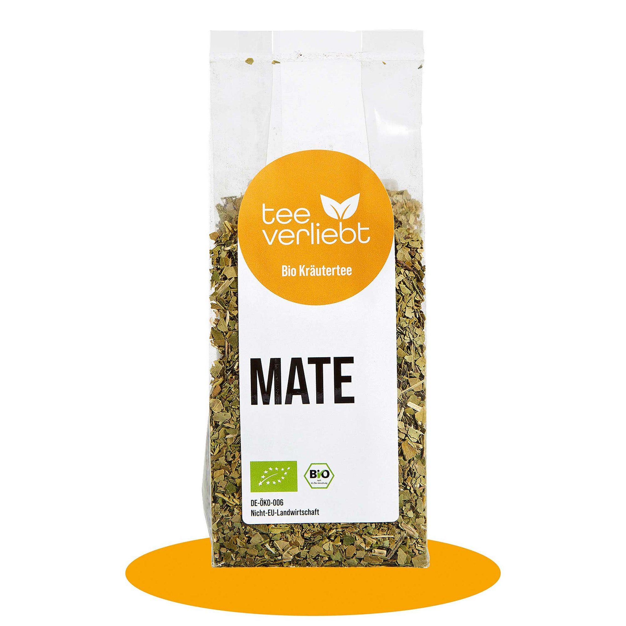 Transparente Verpackung mit losem Mate-Tee. Aufkleber mit Logo, Text 'Bio Kräutertee' und 'MATE'. Bio-Siegel.