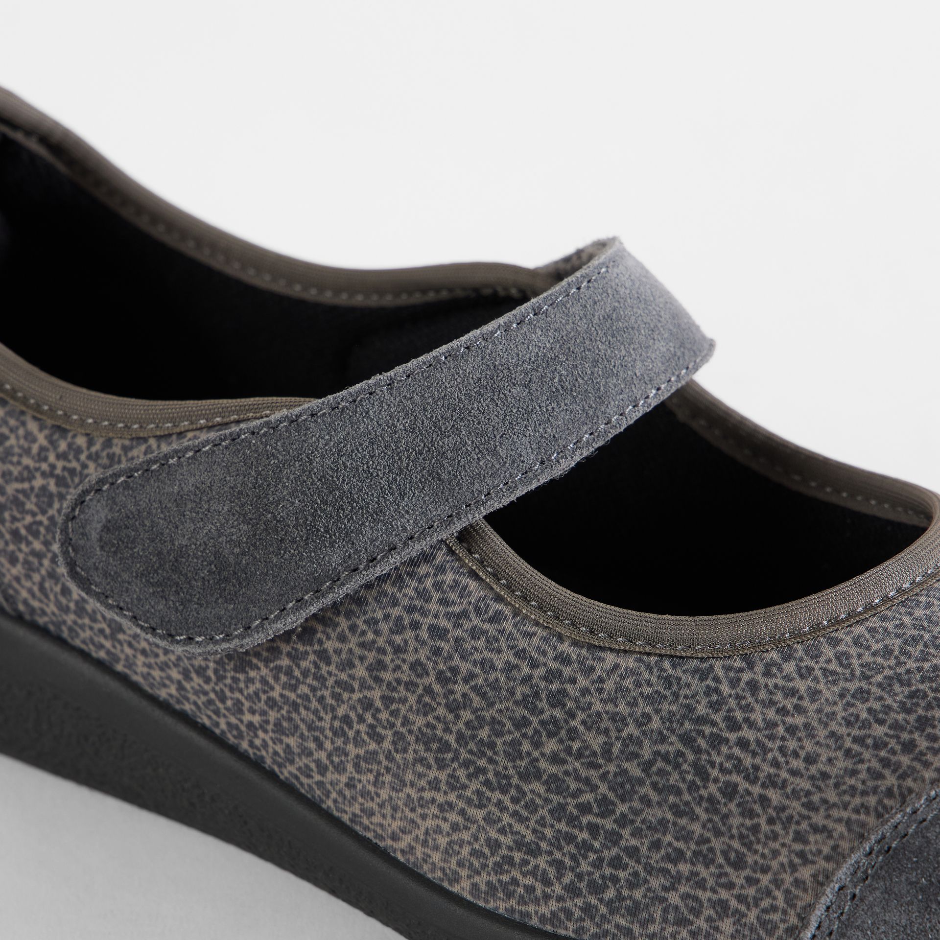 Graue Damenschuhe mit Klettverschluss und gemustertem Obermaterial.
