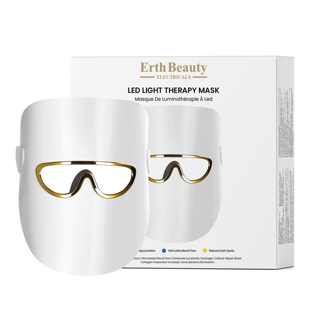 Weiße LED-Lichttherapie-Maske neben ihrer Verpackung, beide mit goldenen Akzenten.