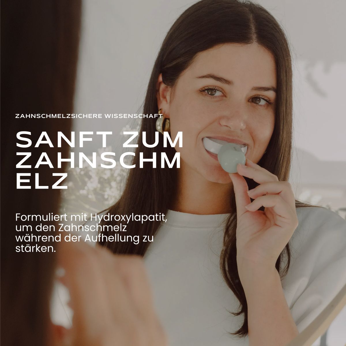 Frau wendet Zahnaufhellungsgerät an, hält Stift und Mundstück.