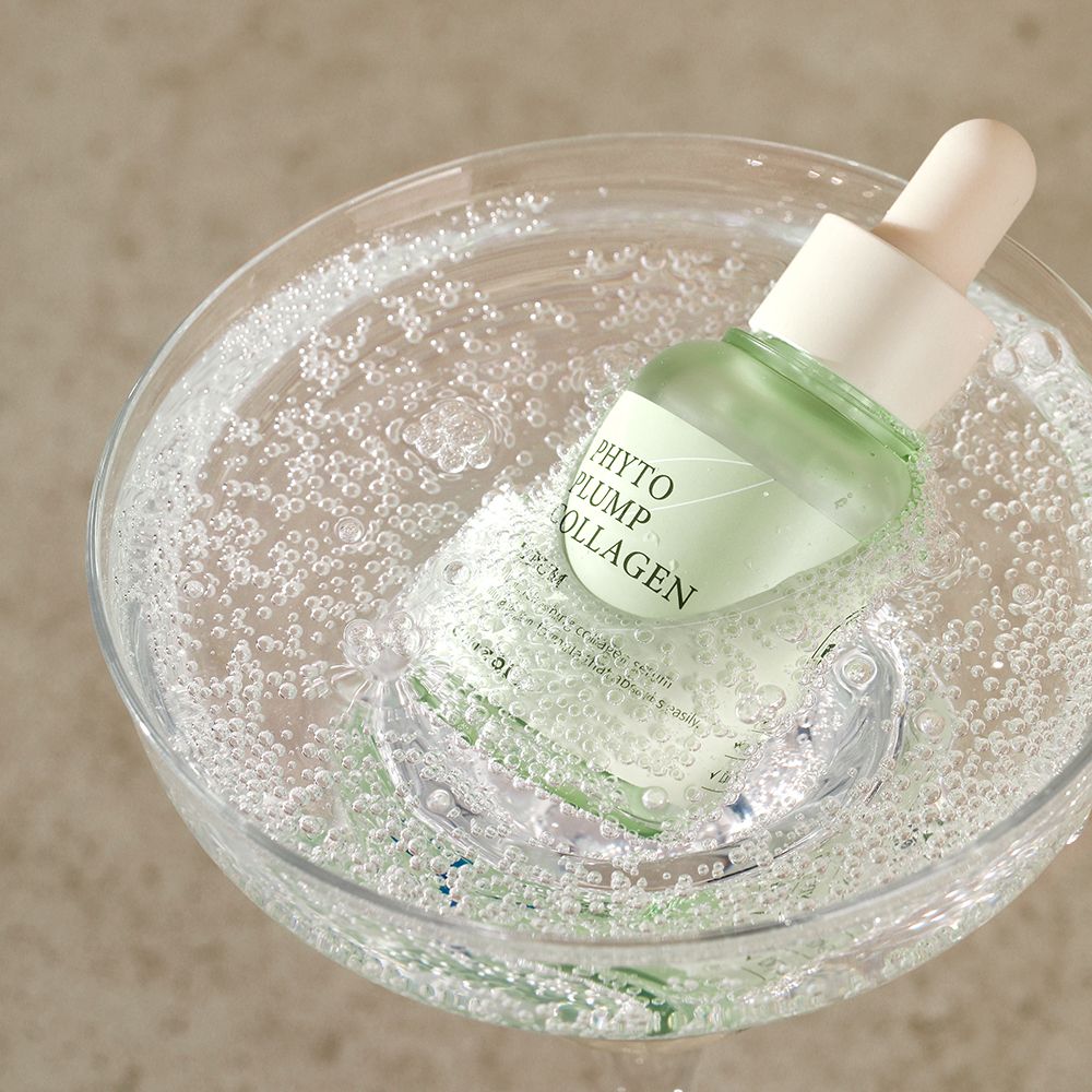 Serumflasche in einem Glas mit Blasen. Produktname 'Phyto Plump Collagen' sichtbar.