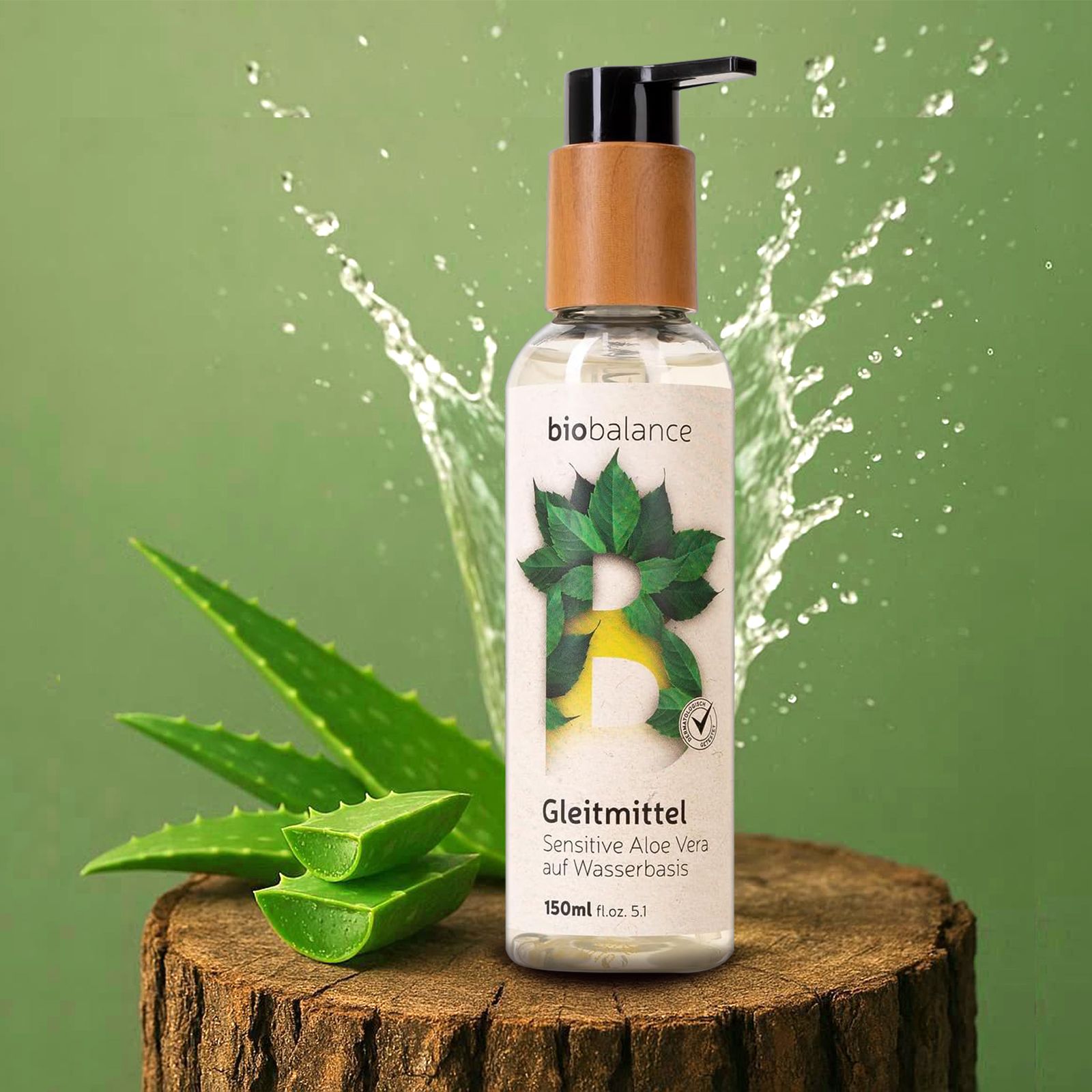 Gleitmittel-Flasche mit Holzdeckel und Pumpkopf auf einem Holzstumpf. Aloe Vera-Blätter und Wasserspritzer.