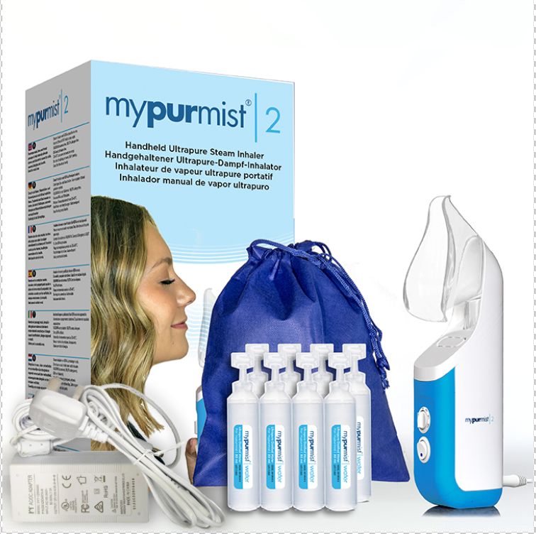 Verpackung mit Inhalator, Zubehör und Frau. Inhalator weiß-blau, mit Mundstück. Zubehör: Netzteil, Ampullen, Beutel. Verpackung mit Produktnamen.