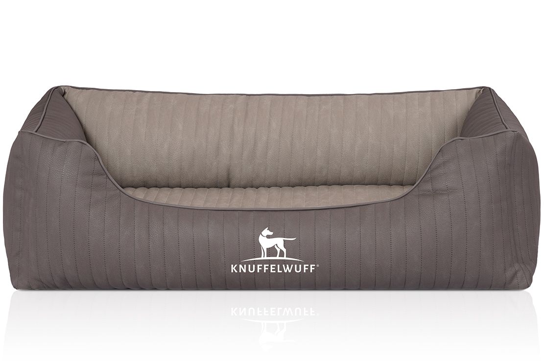 Orthopädisches Hundebett in Grau mit Logo. Rechteckige Form mit erhöhten Seiten und niedriger Front. Gesteppte Oberfläche.