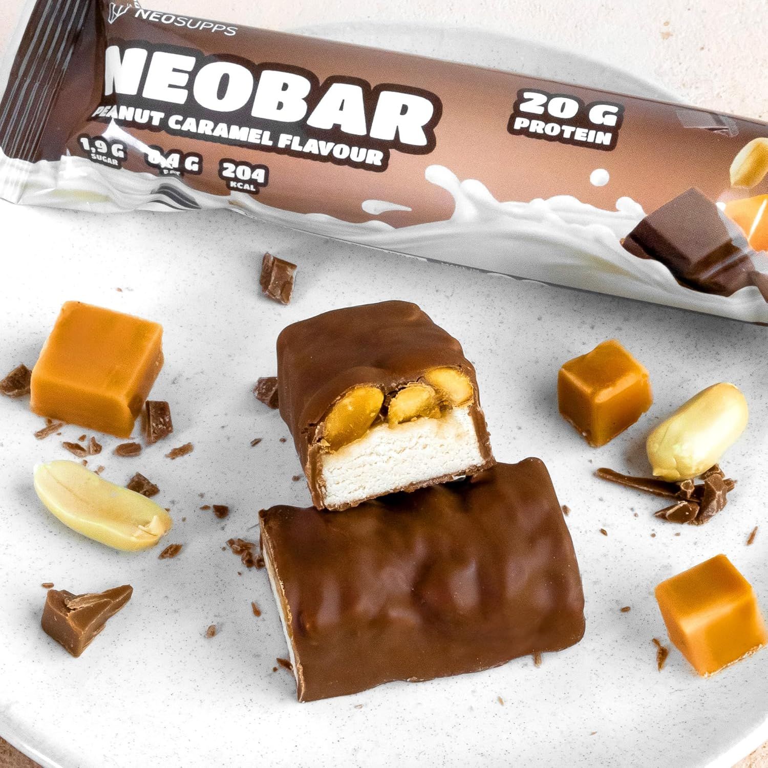 NeoBar-Riegel, angeschnitten. Schokoladenüberzug, Karamellfüllung, Erdnüsse. Aufschrift: NeoBar Peanut Caramel Flavour, 20g Protein.
