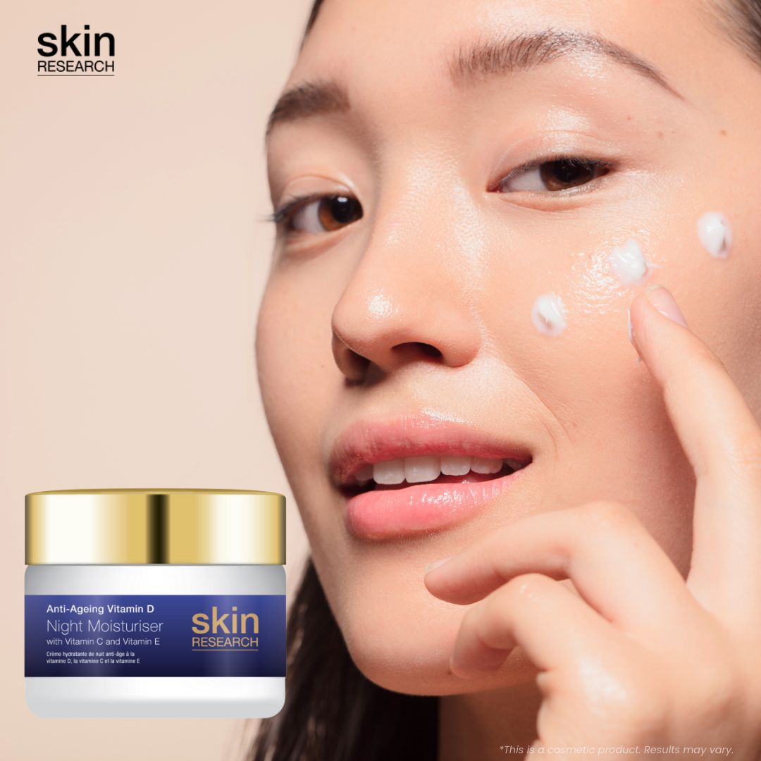Frau trägt Creme auf. Cremebehälter mit goldenem Deckel. Aufschrift: Anti-Aging Vitamin D Night Moisturiser, Vitamin C und E. Marke: skin research.
