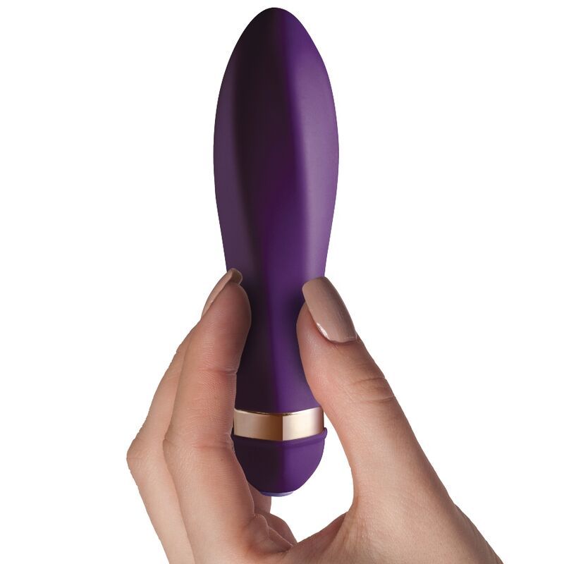 Lila Vibrator in einer Hand gehalten. Goldfarbener Ring am unteren Ende.