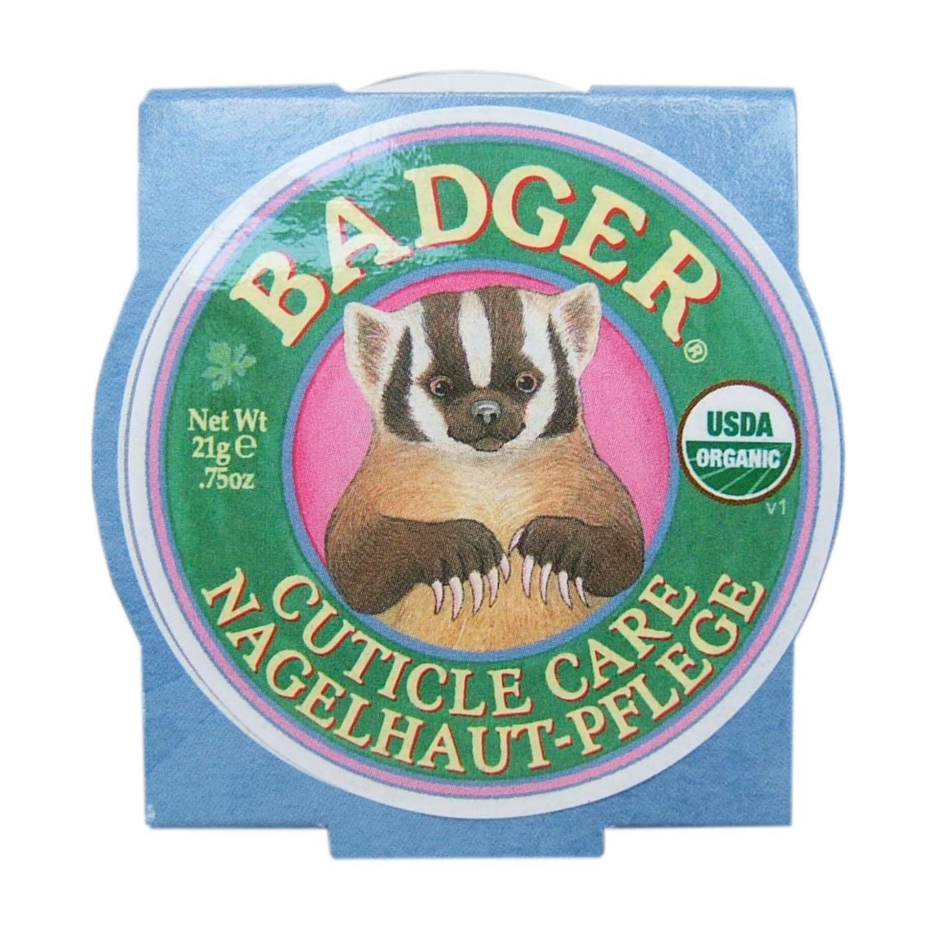 Quadratische Verpackung mit rundem Aufkleber. Aufkleber: BADGER, CUTICLE CARE, NAGELHAUT-PFLEGE, USDA Organic. Abbildung eines Dachses.