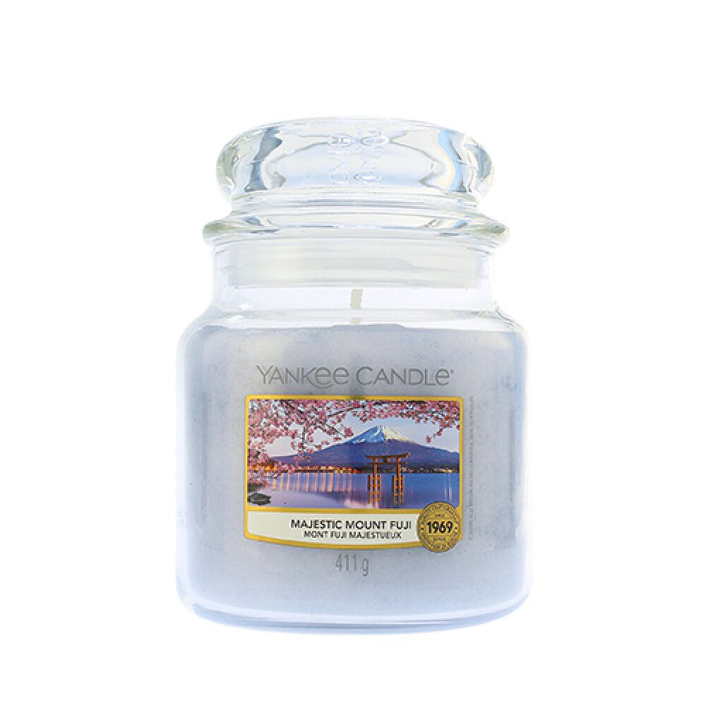 Duftkerze im Glas mit Deckel. Etikett mit Landschaftsmotiv und Schriftzug "Majestic Mount Fuji". Marke: Yankee Candle. 411g.