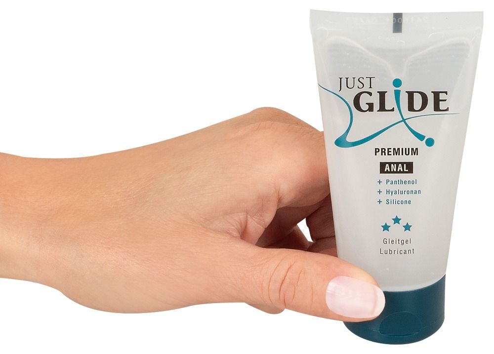 Hand hält Tube. Aufschrift: Just Glide Premium Anal. Enthält Panthenol, Hyaluronan, Silikon. Medizinische Gleitgel. Transparentes Gel.