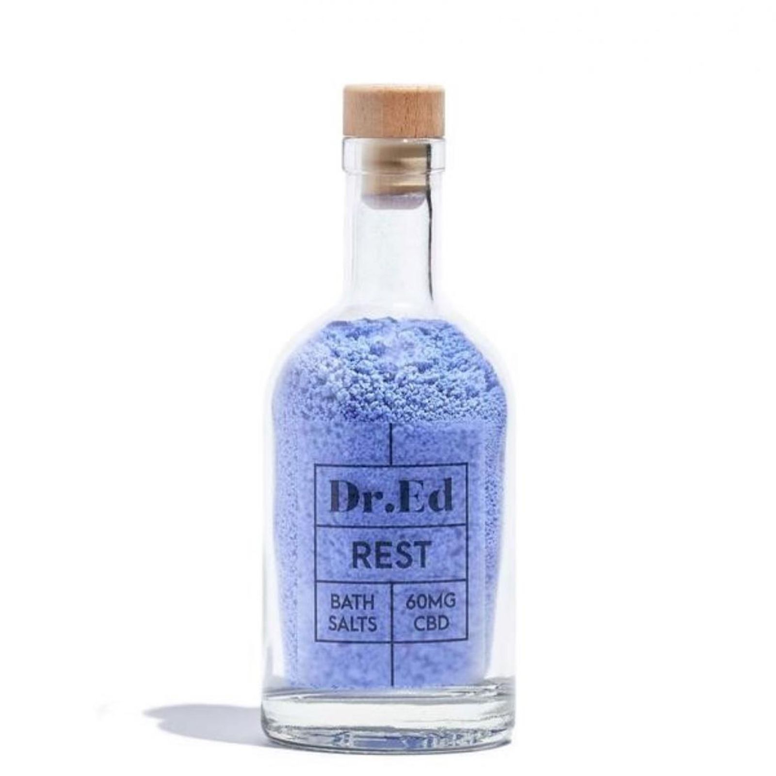Glasflasche mit blauem Badesalz. Aufschrift: Dr.Ed, REST, BATH SALTS, 60MG CBD. Holzverschluss.