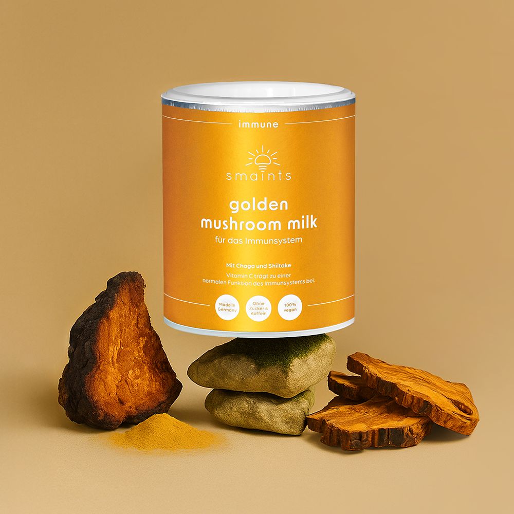 Dose mit smaints Golden Mushroom Milk. Mit Chaga und Shiitake. Auf Holzstücken und Pilzpulver.