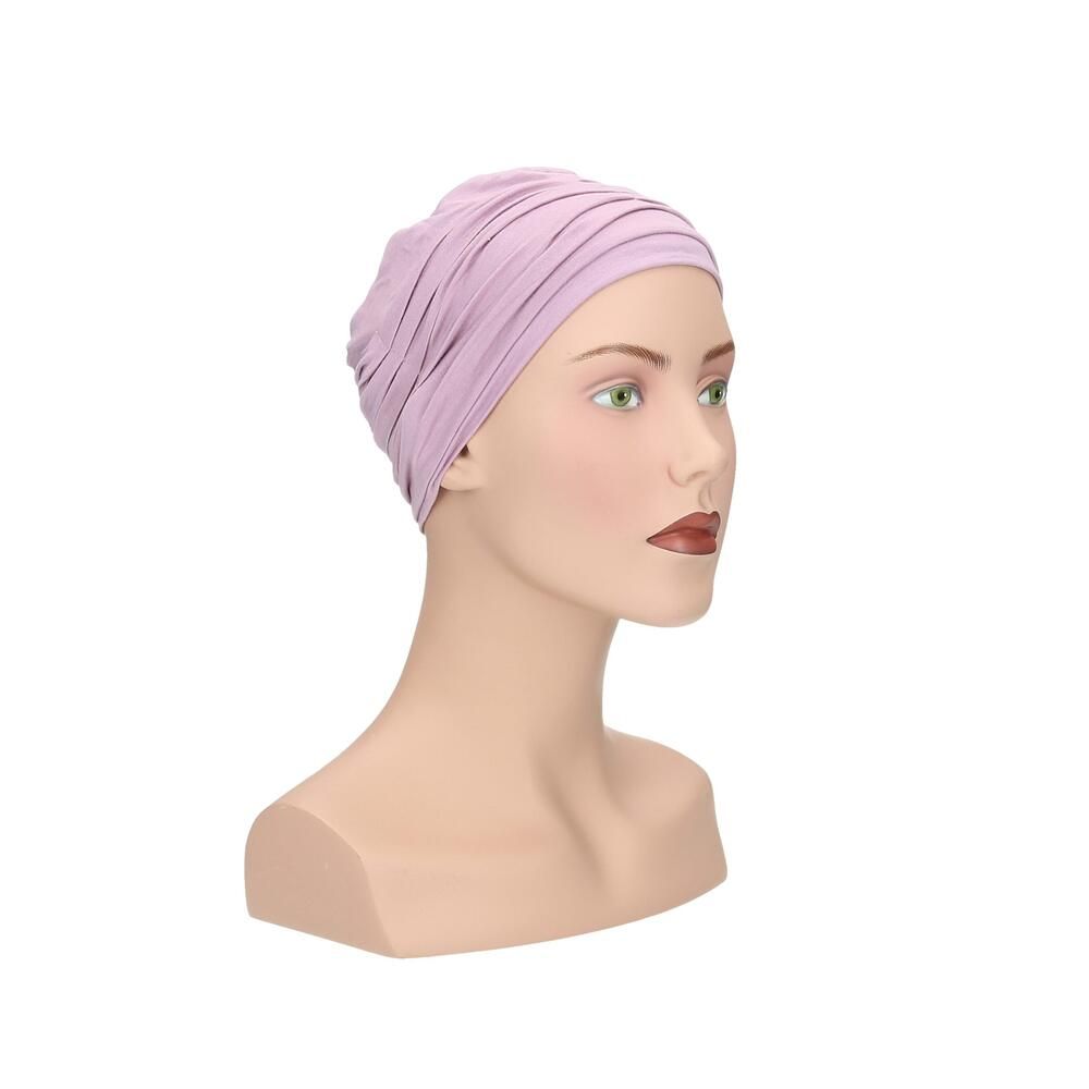 Helllila Turban auf einer Büste. Der Turban hat eine gerüschte Struktur.