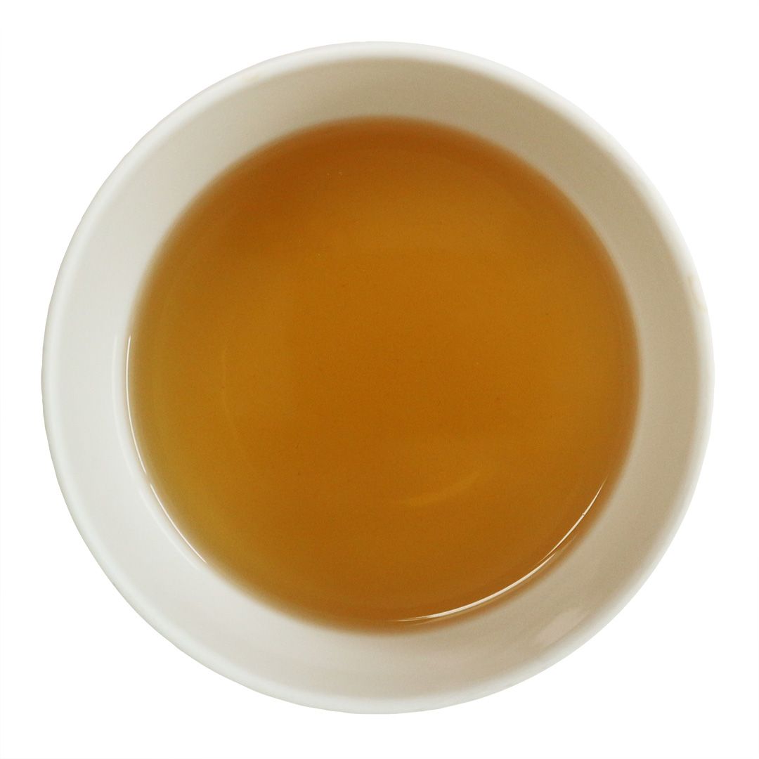 Weisse Schale mit goldgelbem Tee. Draufsicht.