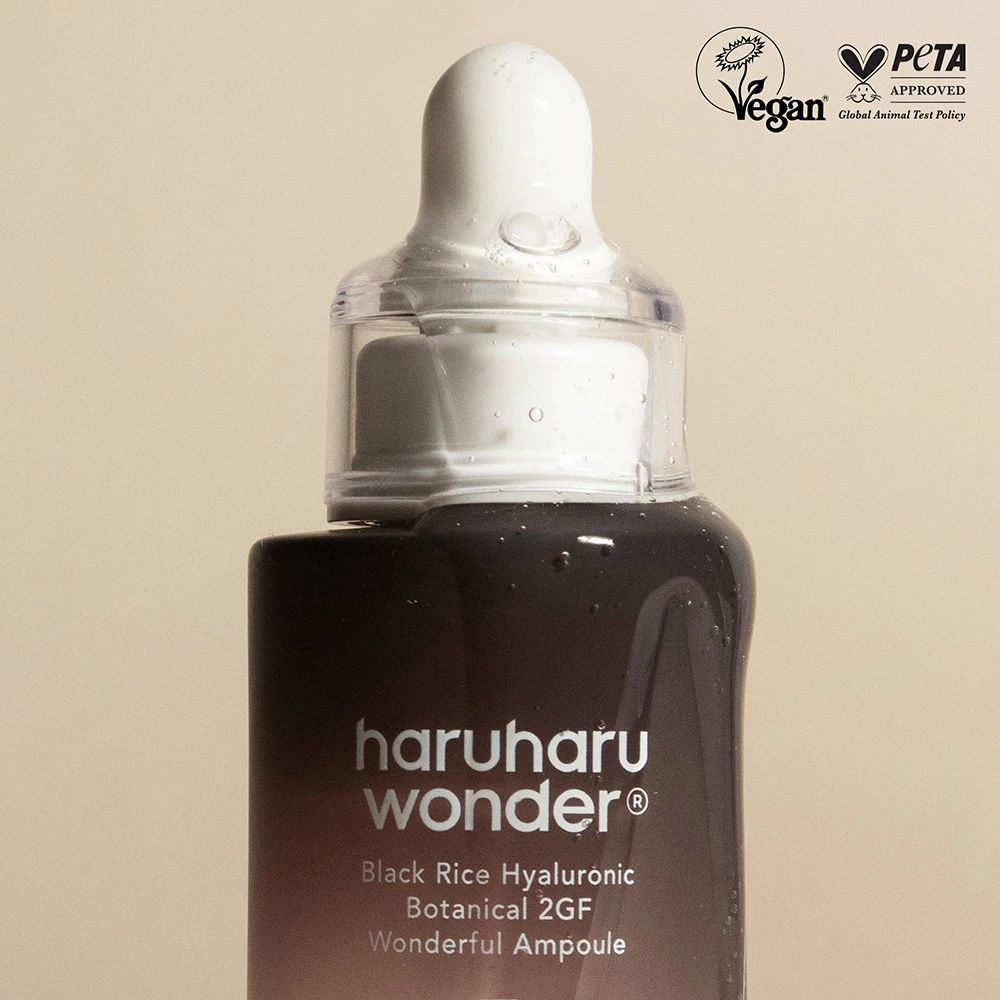 Nahaufnahme der Serumflasche mit Pipette. Vegan- und PETA-Siegel. Schriftzug: haruharu wonder, Black Rice Hyaluronic.