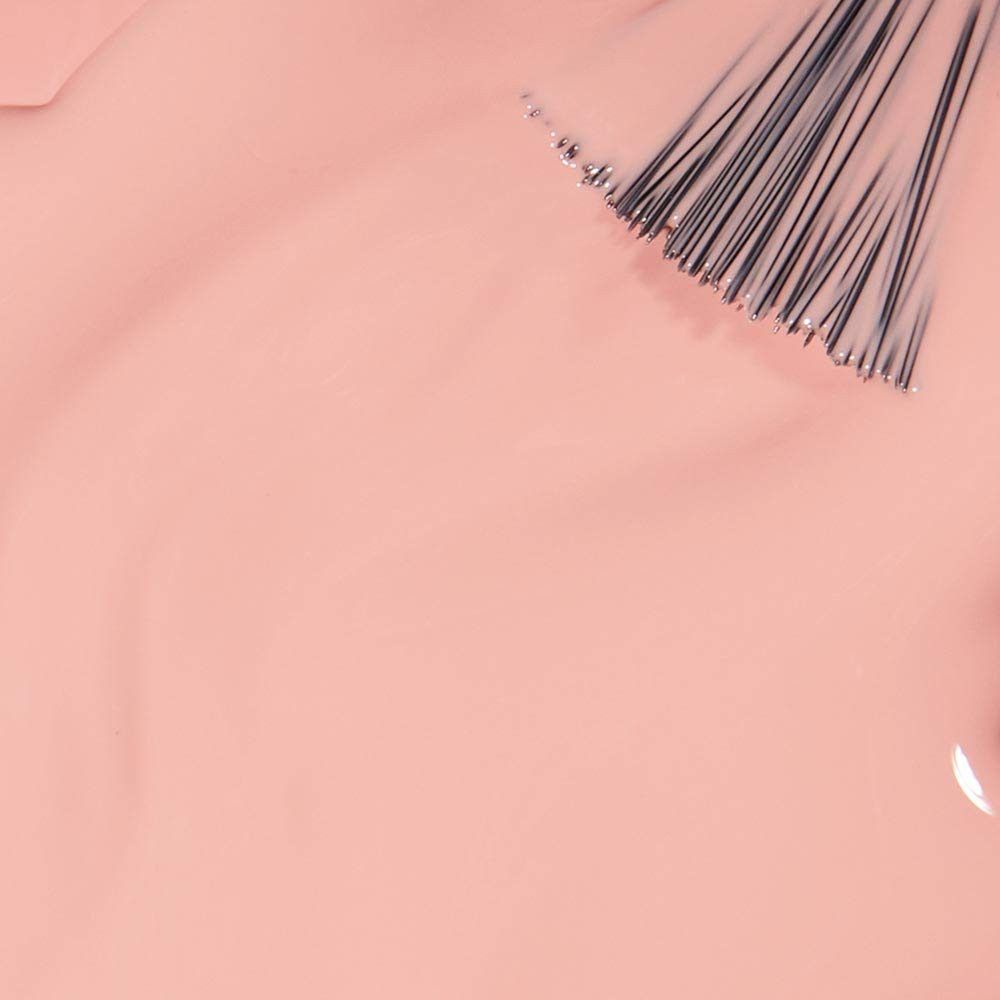 Hellrosa Nagellack mit Pinsel. Der Pinsel berührt die glatte, cremige Oberfläche des Lacks.