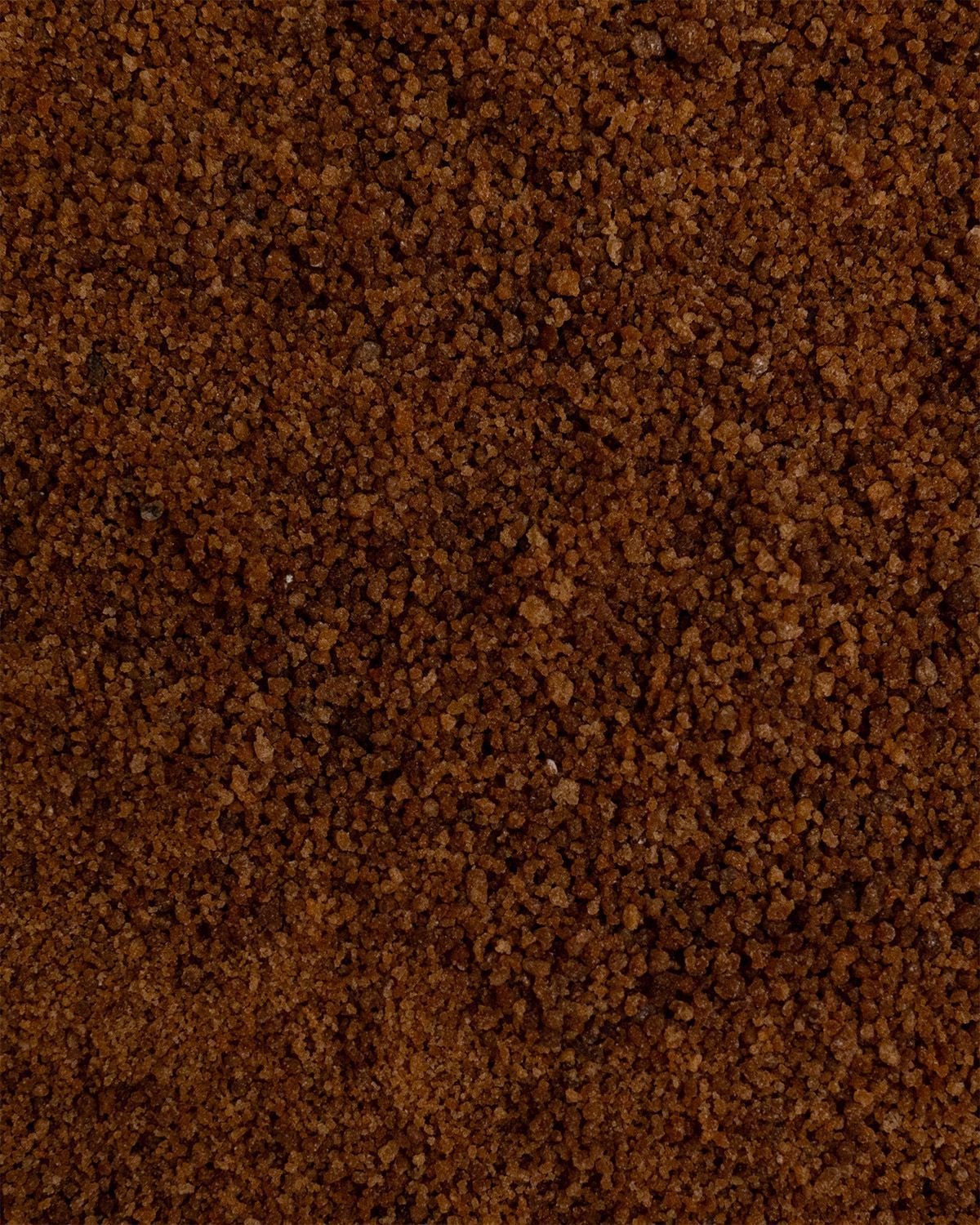 Nahaufnahme von braunem, körnigem Zucker. Textur sichtbar.