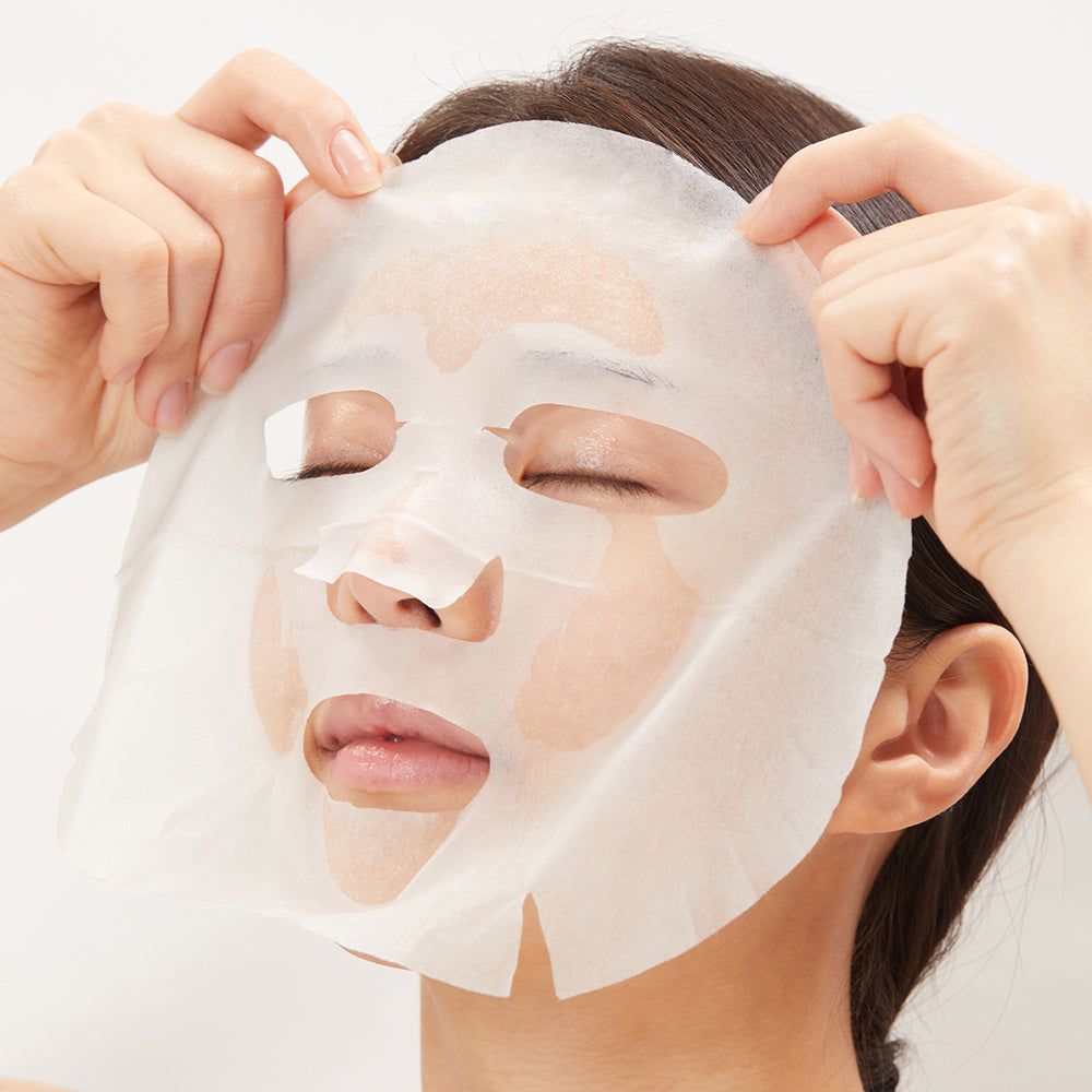 Hände legen eine Maske auf ein Gesicht. Maske mit Augen-, Nasen- und Mundöffnungen. Weiße Farbe.