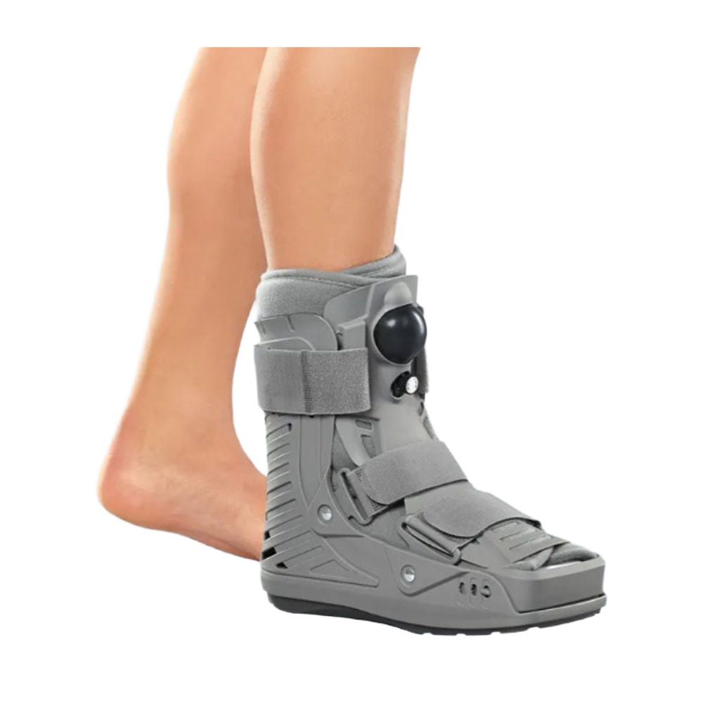 Grauer Walker-Stiefel mit Klettverschlüssen und Riemen, der an einem Bein befestigt ist.