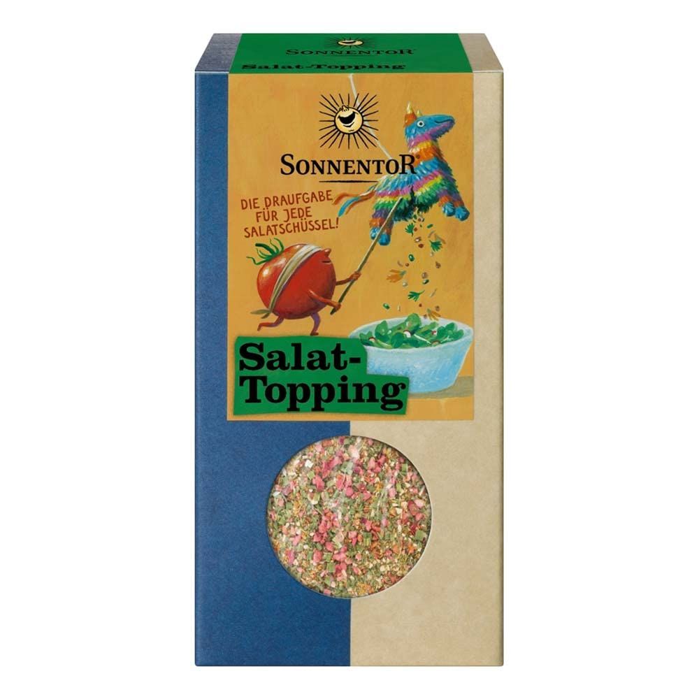 Sonnentörr Salat-Topping Karton mit Sichtfenster, zeigt eine Tomate, die eine Piñata zerschlägt.